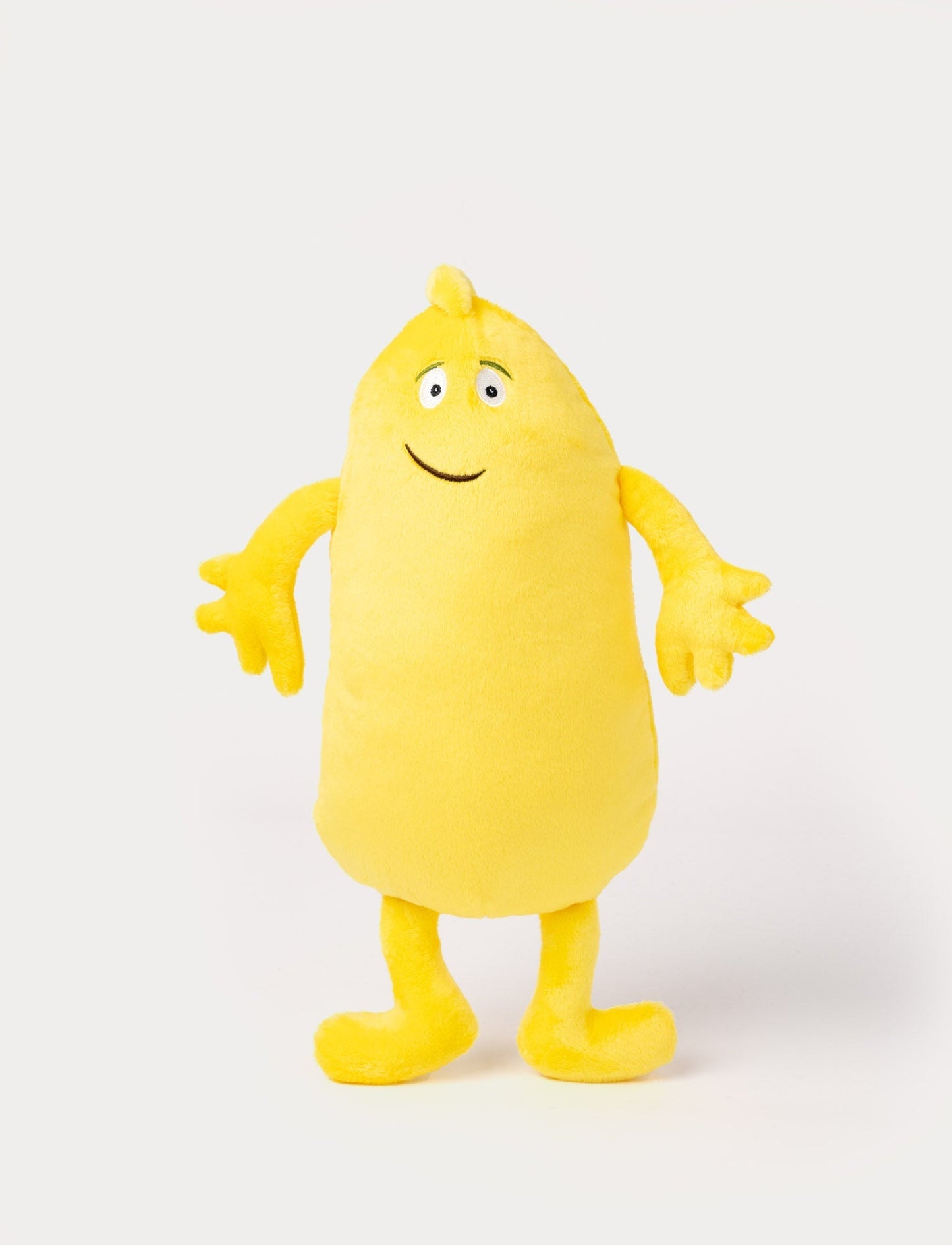 Yellow plush toy with an elongated body, small tuft on top, big eyes, and a friendly embroidered smile.