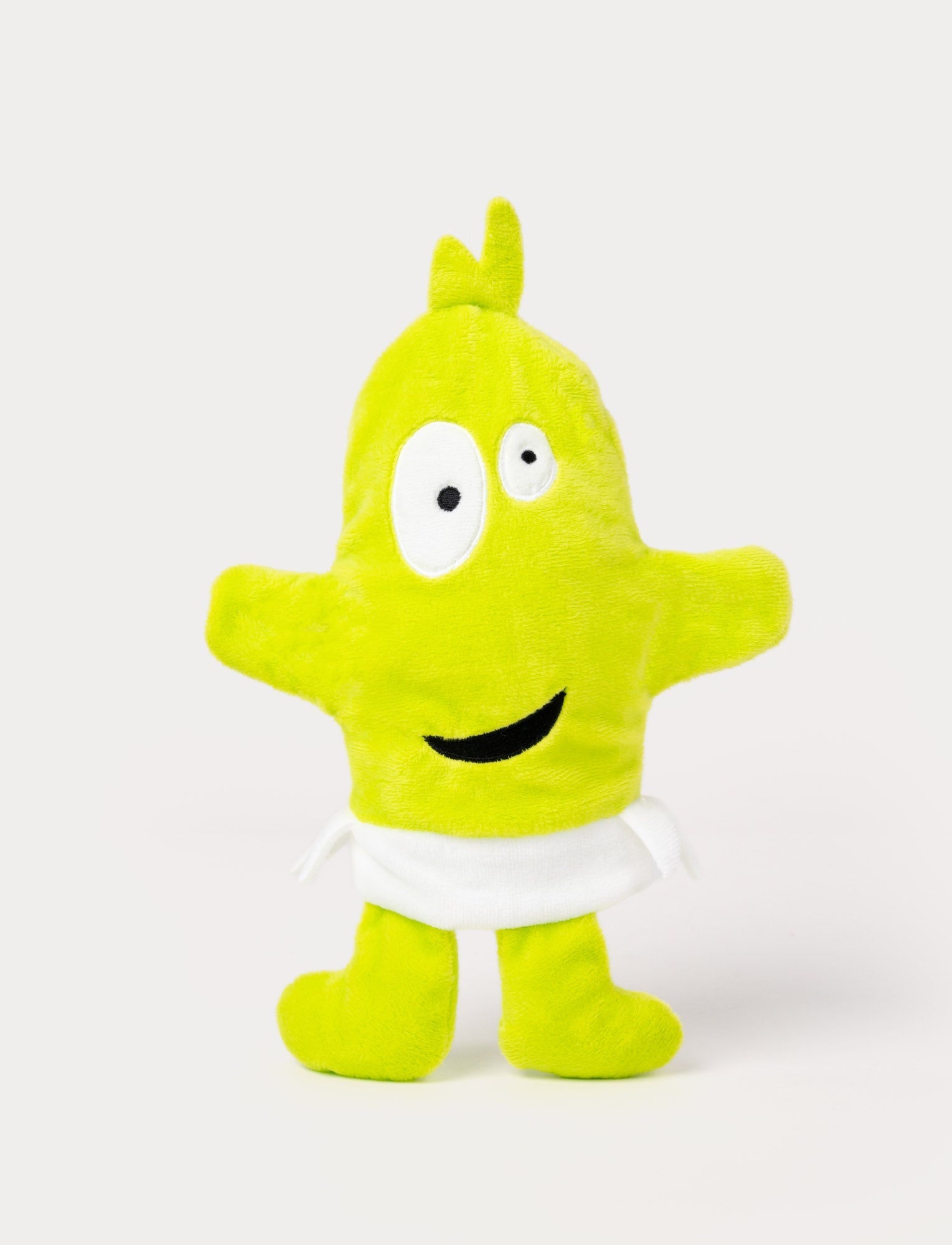  Image of Green hand puppet with a tuft on top, large uneven eyes, a playful smile, and a white waistband.