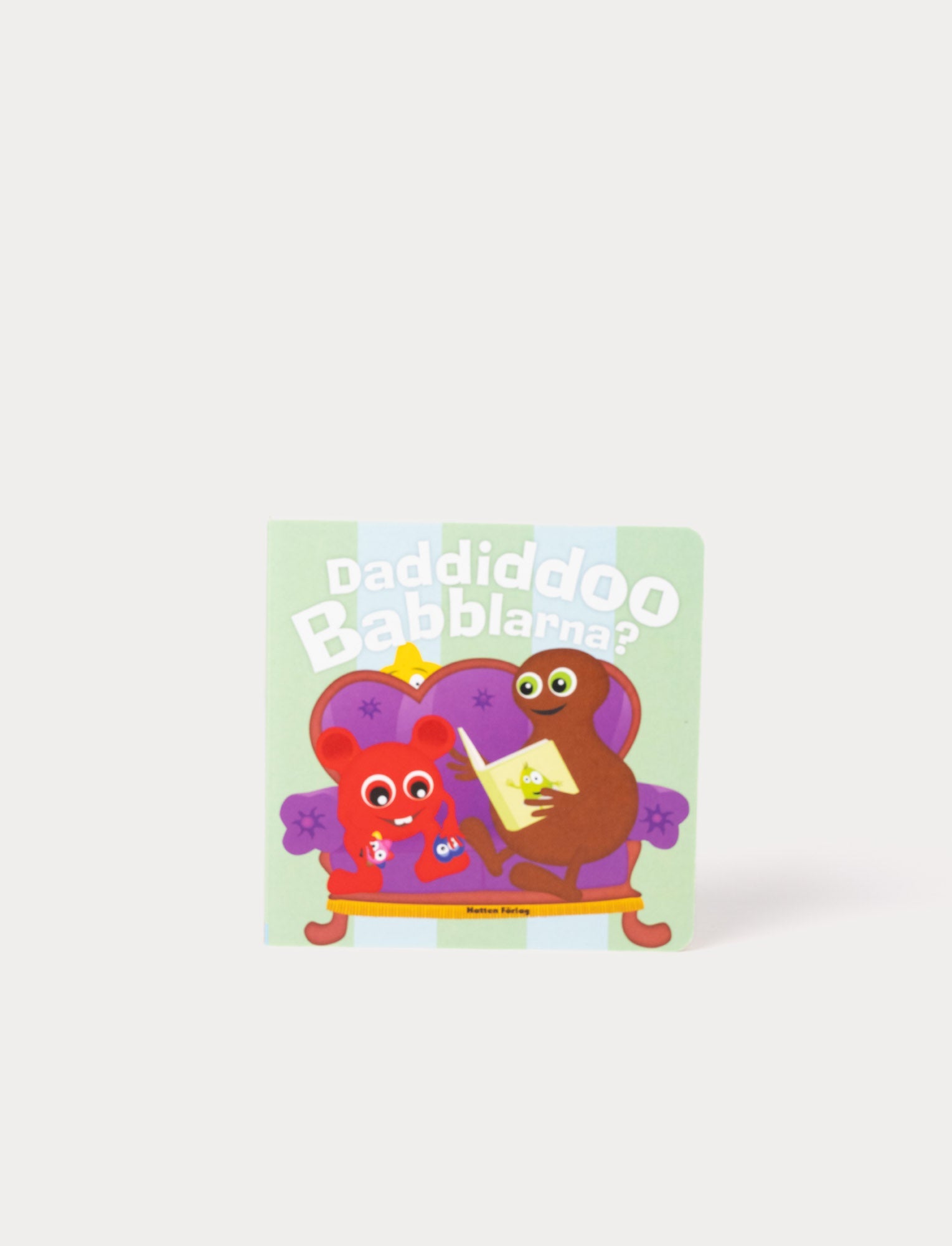  Image of children's book with colorful Babblarna characters in a cozy living room scene.
