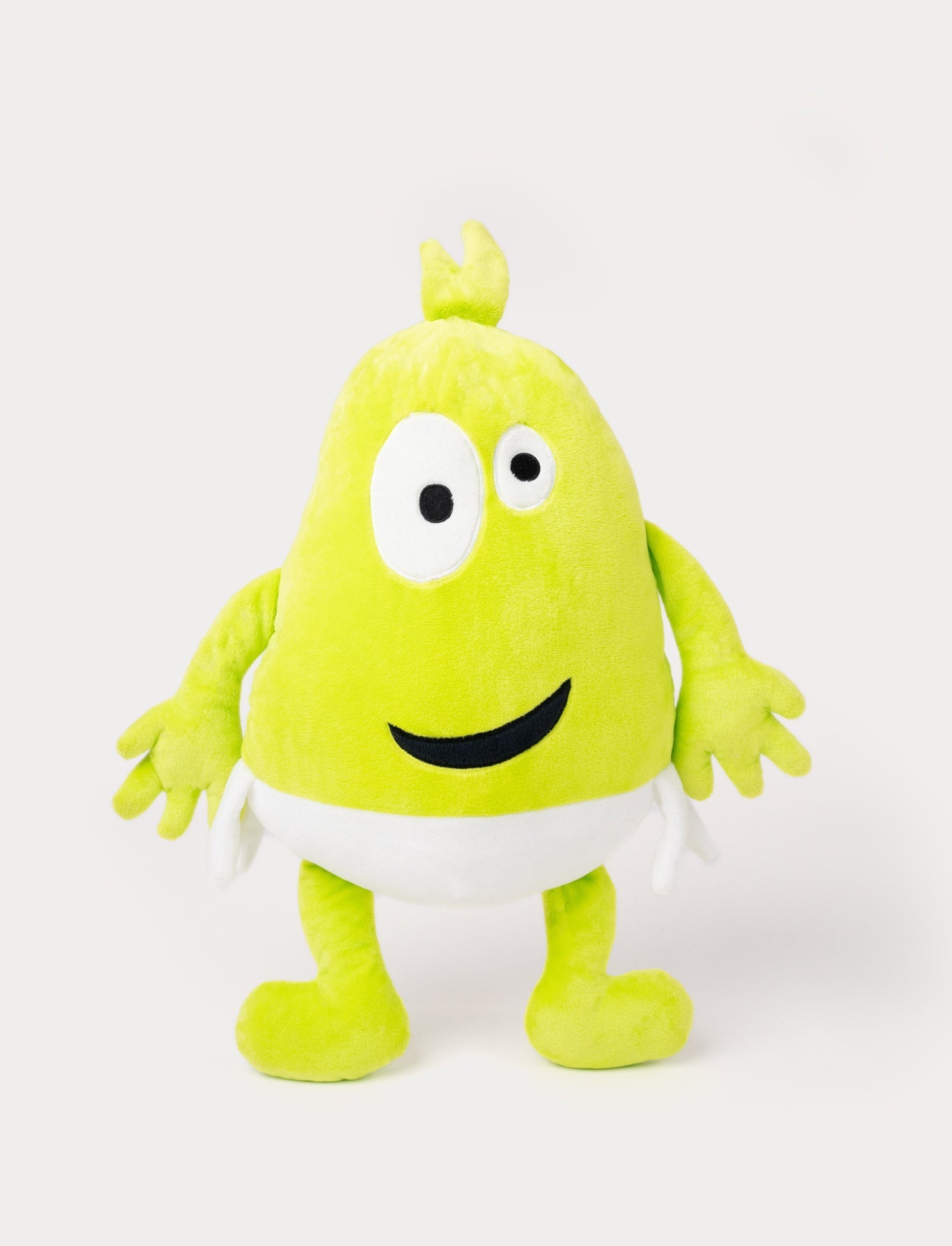  Image of Green plush toy with a tuft on top, large uneven eyes, a playful smile, and a white waistband.