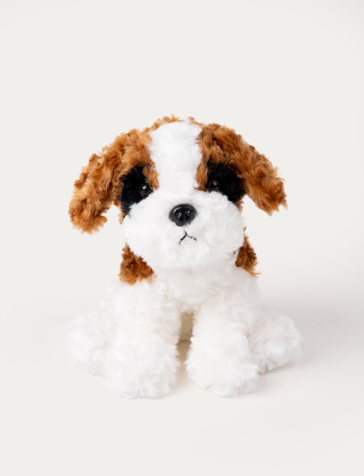  Image of A white, curly plush dog with a friendly expression and soft fur.