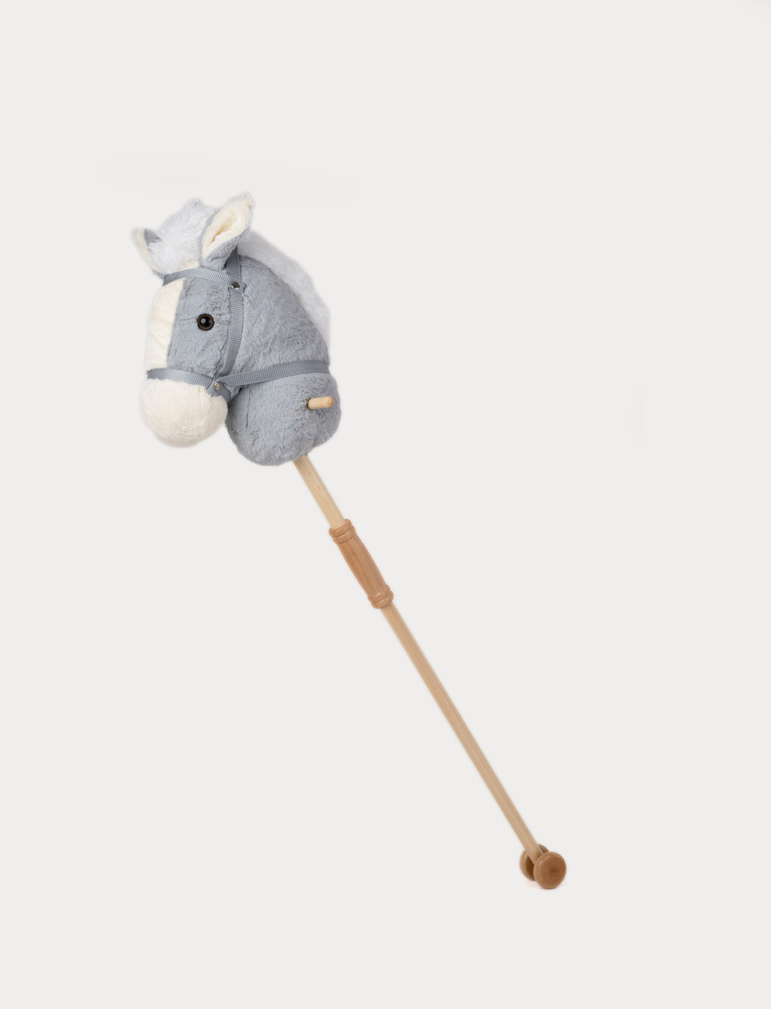  Image of Plush hobby horse with a grey head, white muzzle, soft mane, and a wooden stick with wheels.