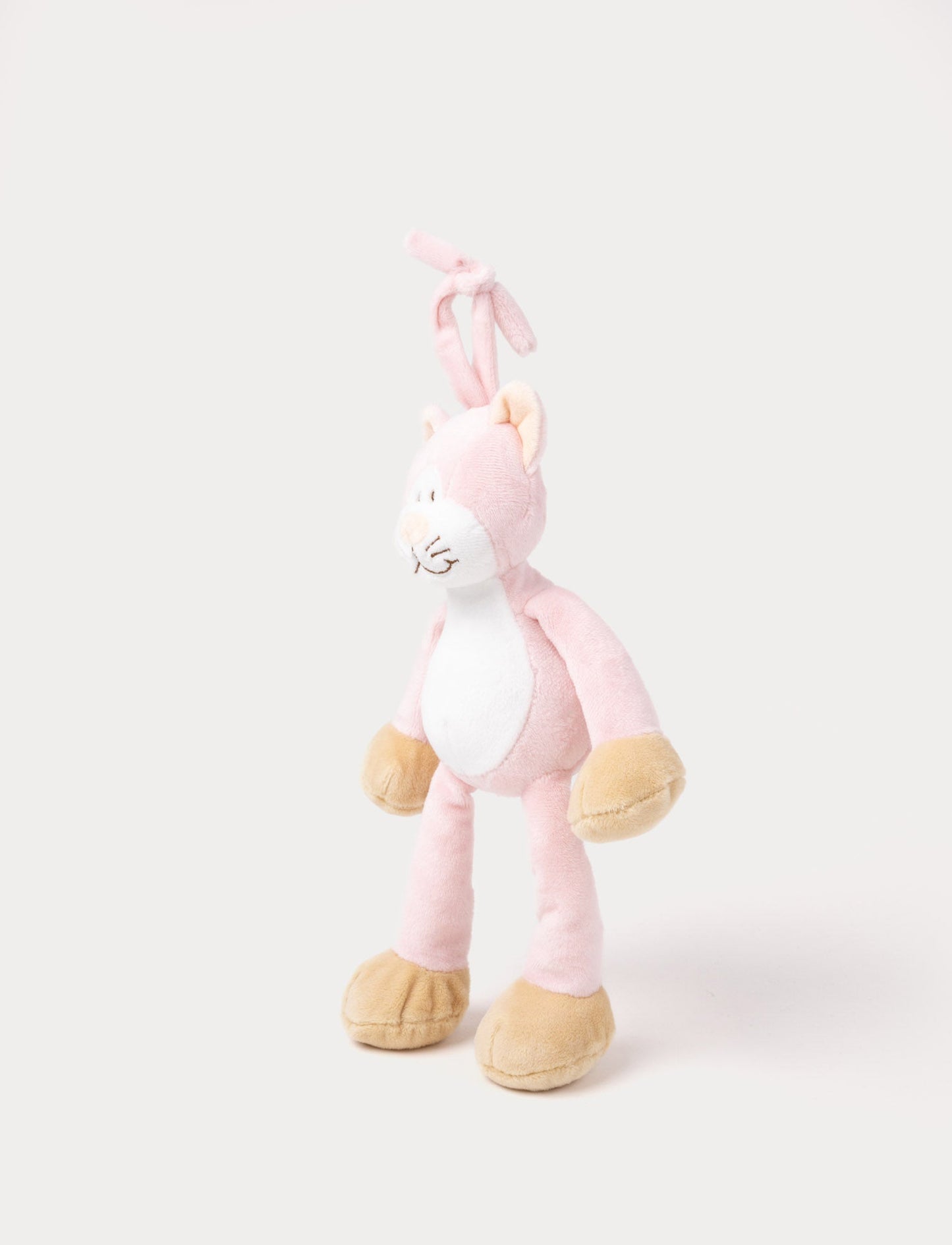 A plush pink cat music box toy with a white belly, beige paws, a stitched smiling face, and a fabric loop on top for hanging