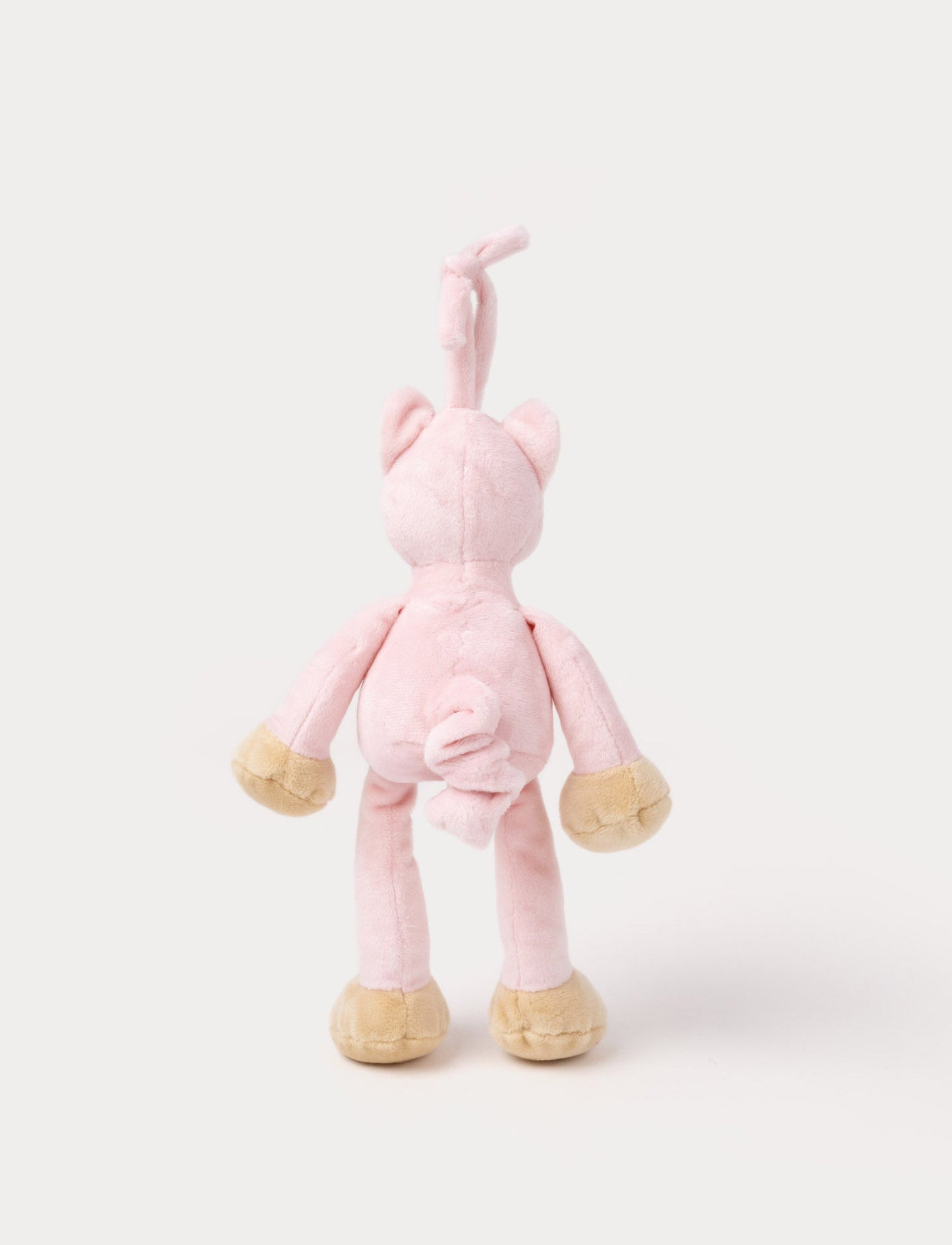 A plush pink cat music box toy with a white belly, beige paws, a stitched smiling face, and a fabric loop on top for hanging