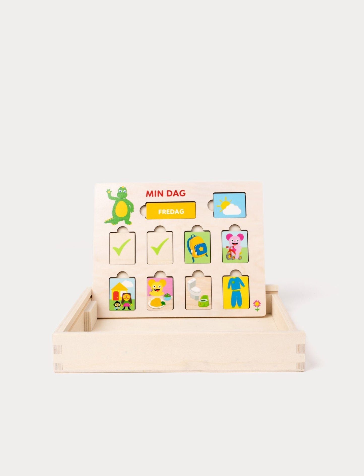 A wooden daily planner board featuring the Bolibompa dragon and interchangeable activity pieces.