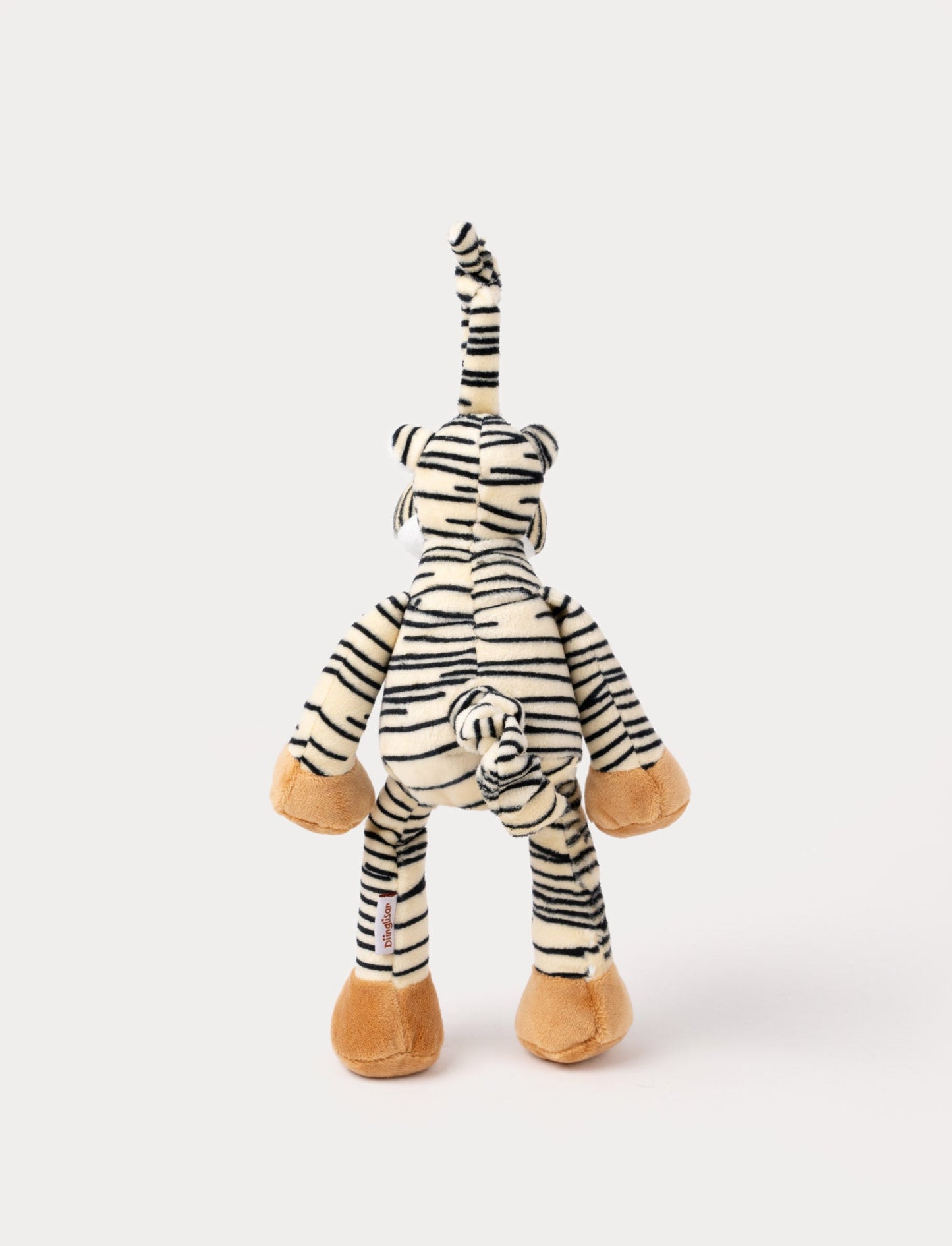 A plush tiger music box with black stripes, a white belly, beige paws, and a fabric loop for hanging