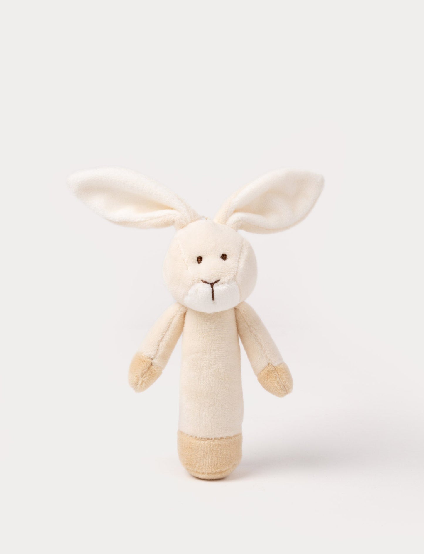 Soft plush bunny rattle with a light beige body, long floppy ears, embroidered eyes, and white accents on the muzzle and base.