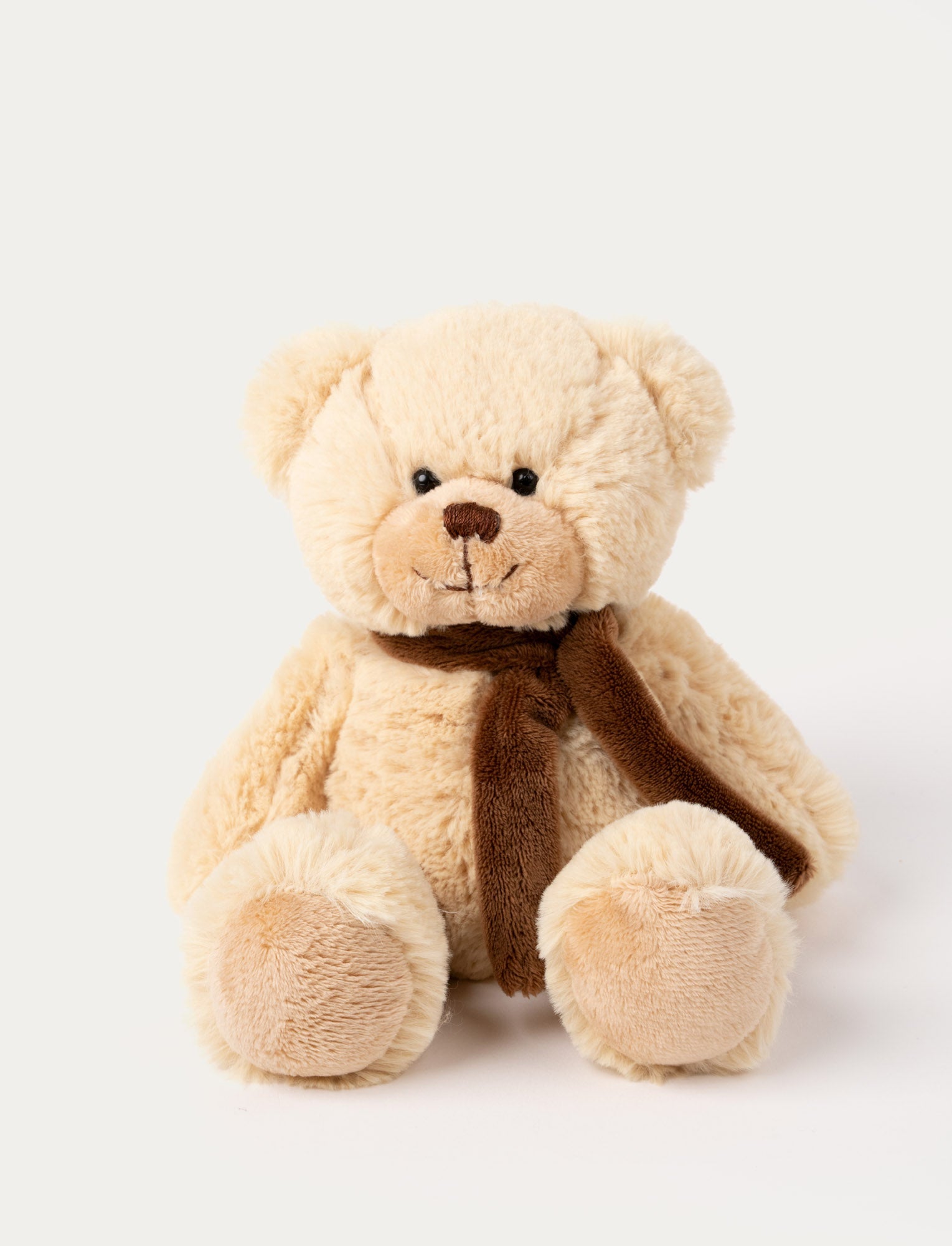 Image of A beige teddy bear with soft fur and a cozy scarf.