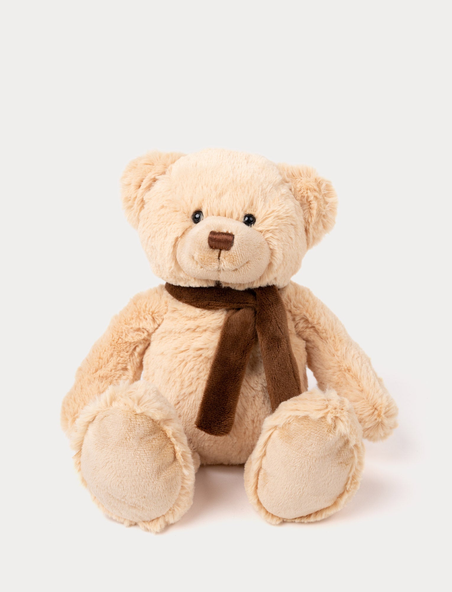 Image of Classic beige teddy bear with black eyes, a stitched brown nose, and a soft brown scarf around its neck.