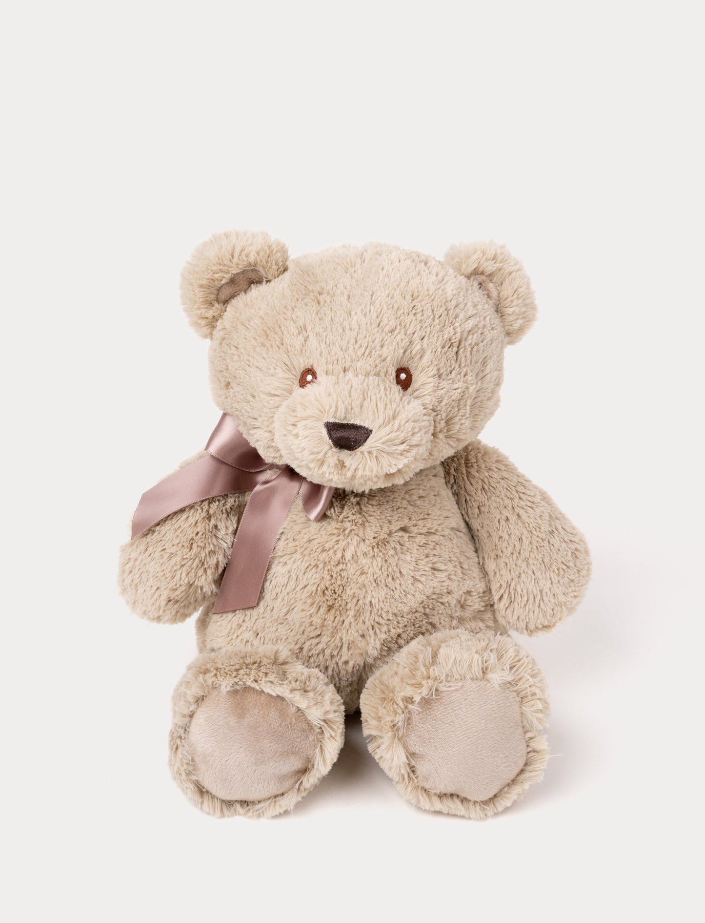 Soft, beige teddy bear with a stitched brown nose, brown eyes, and a mauve satin ribbon tied around its neck.