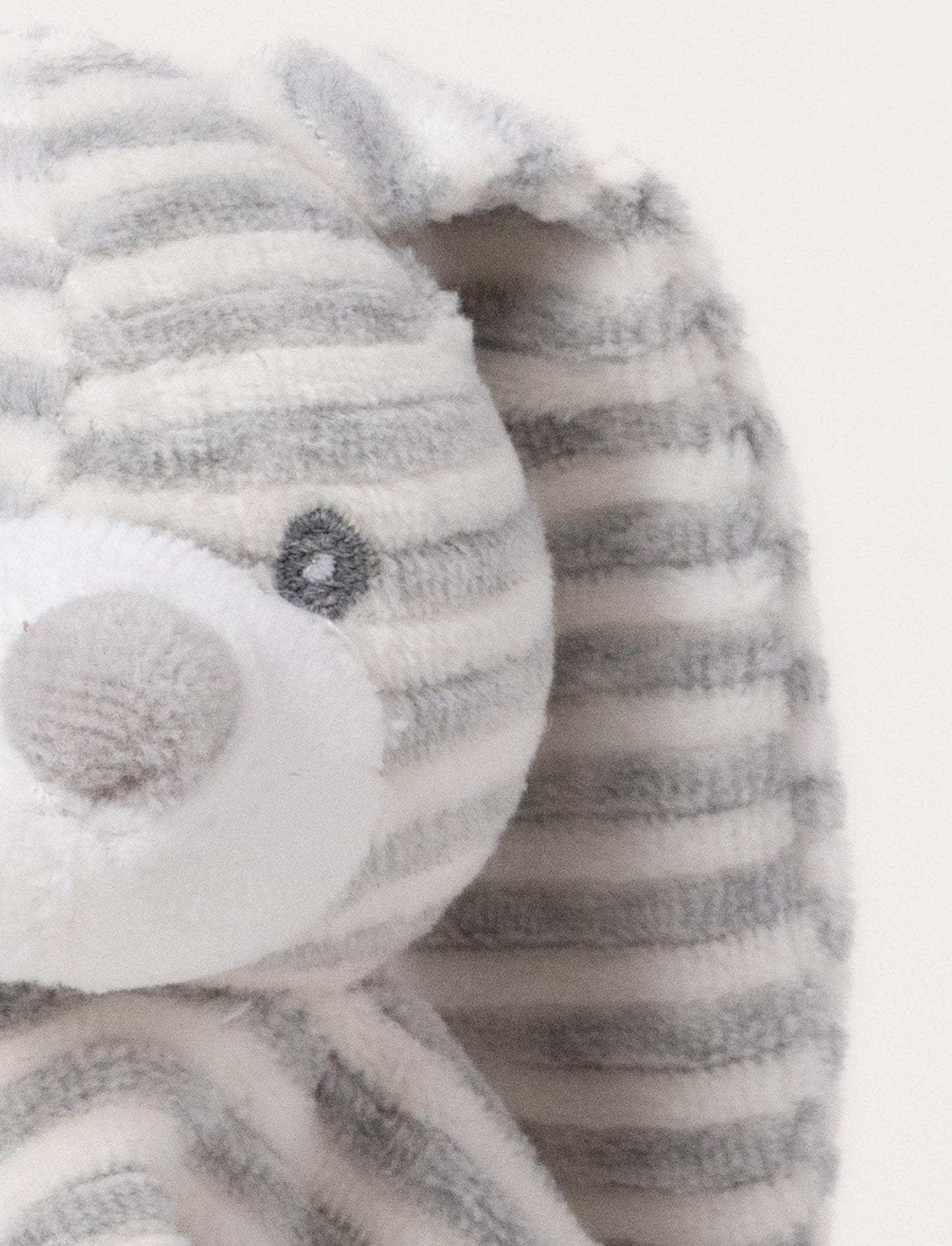 A grey and white striped plush bunny comforter with floppy ears and knotted fabric ends.