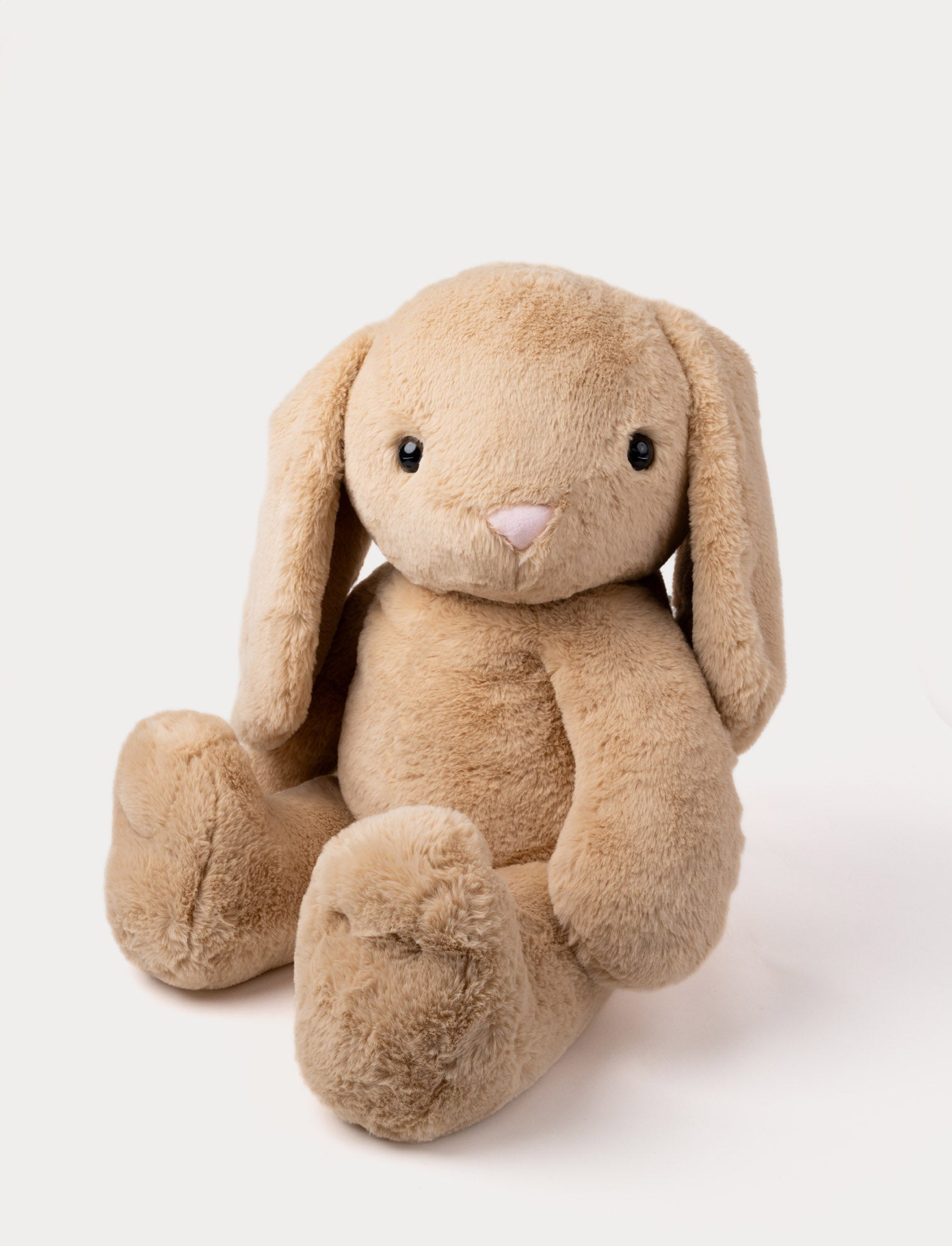  Image of Soft beige plush bunny with long floppy ears, a pink nose, and a cuddly, fluffy texture.