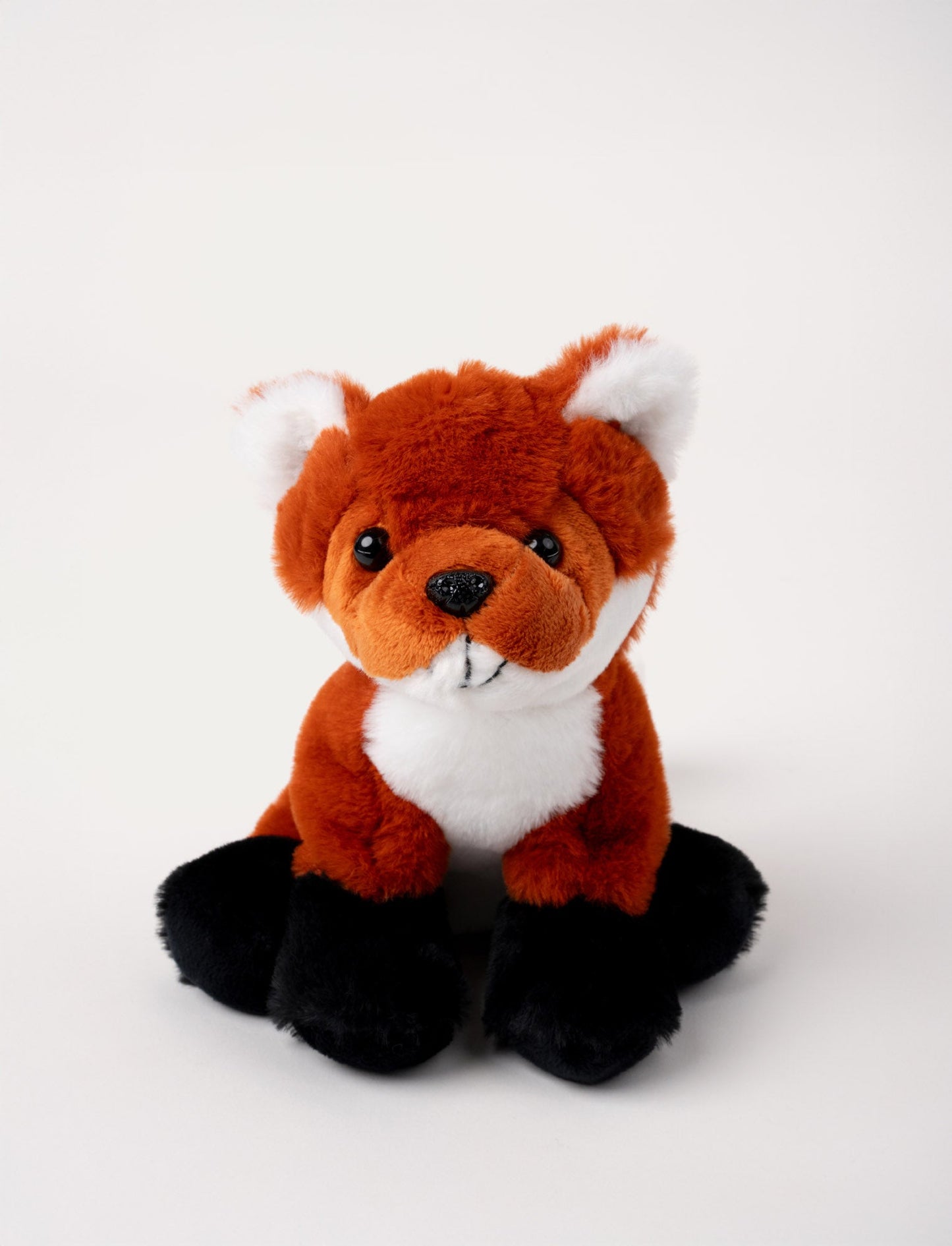 Soft red fox plush with white accents, black paws, and shiny black eyes.