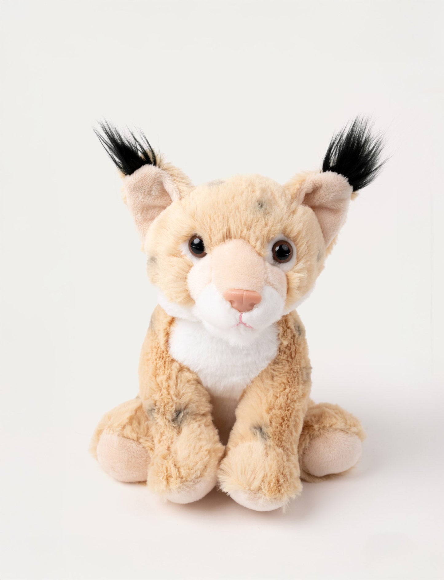 Soft lynx plush with beige fur, black ear tufts, white accents, and shiny brown eyes.