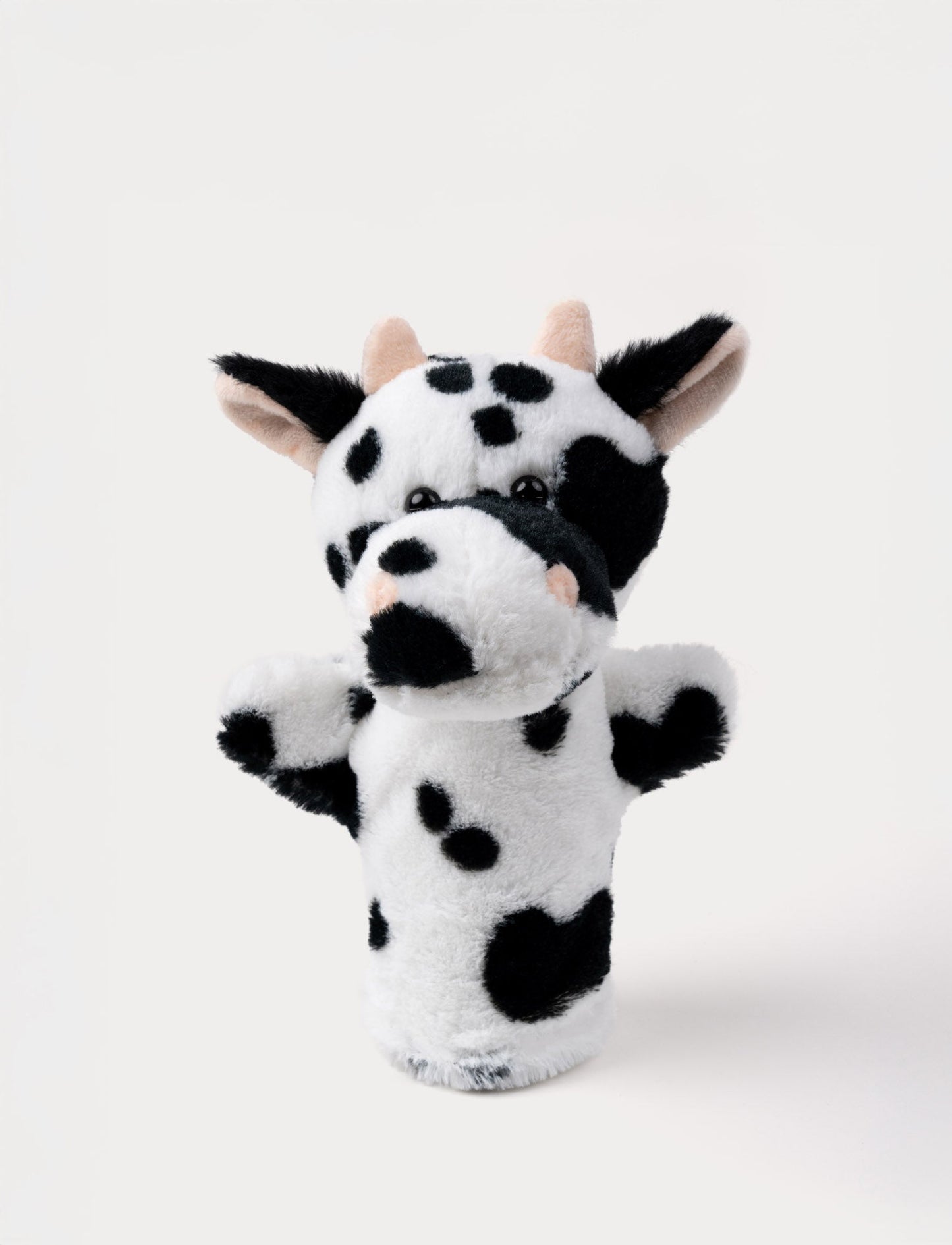 Soft black and white cow hand puppet with pink horns, floppy ears, and shiny black eyes.