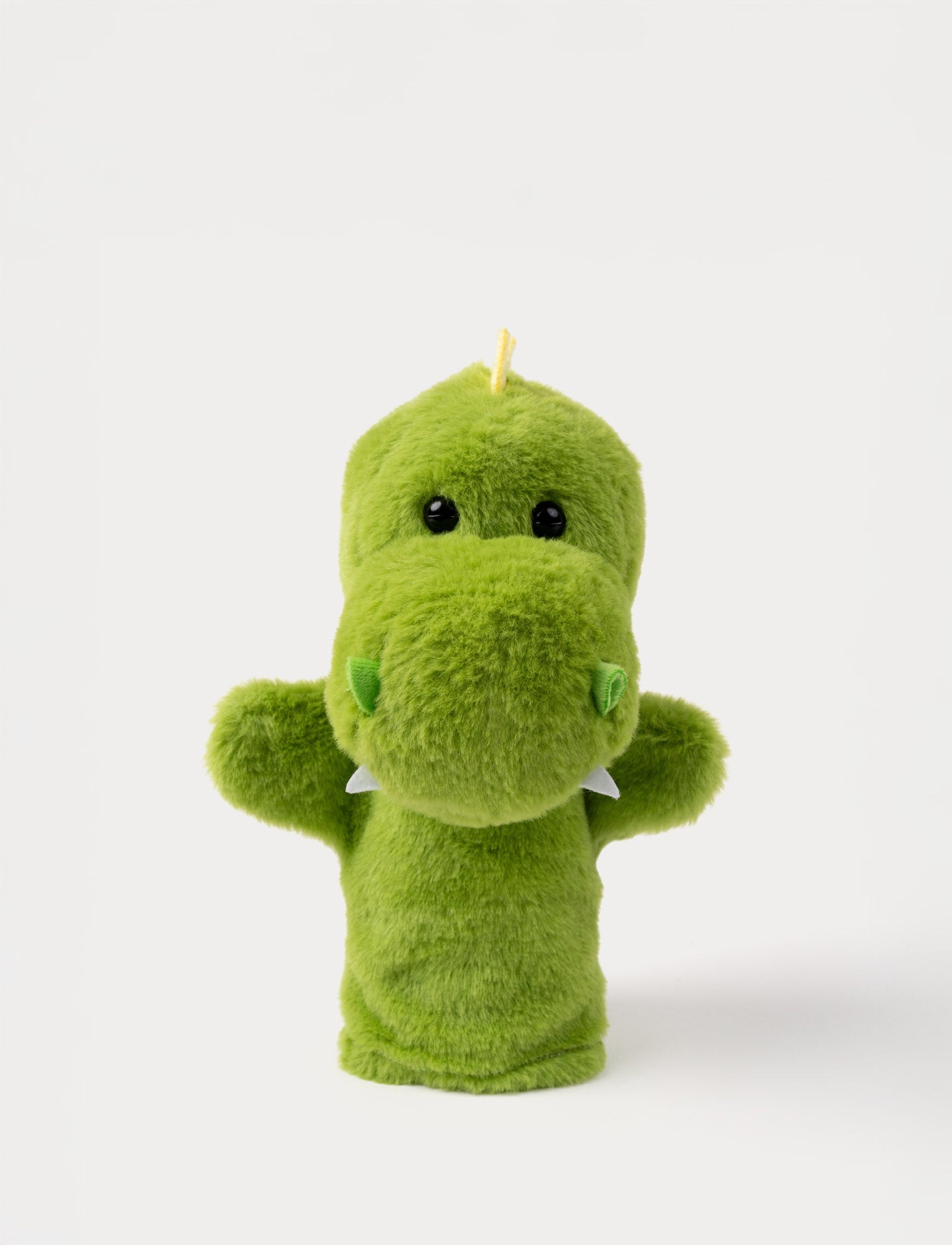  Image of Soft green dinosaur hand puppet with tiny white teeth, a yellow crest, and shiny black eyes.