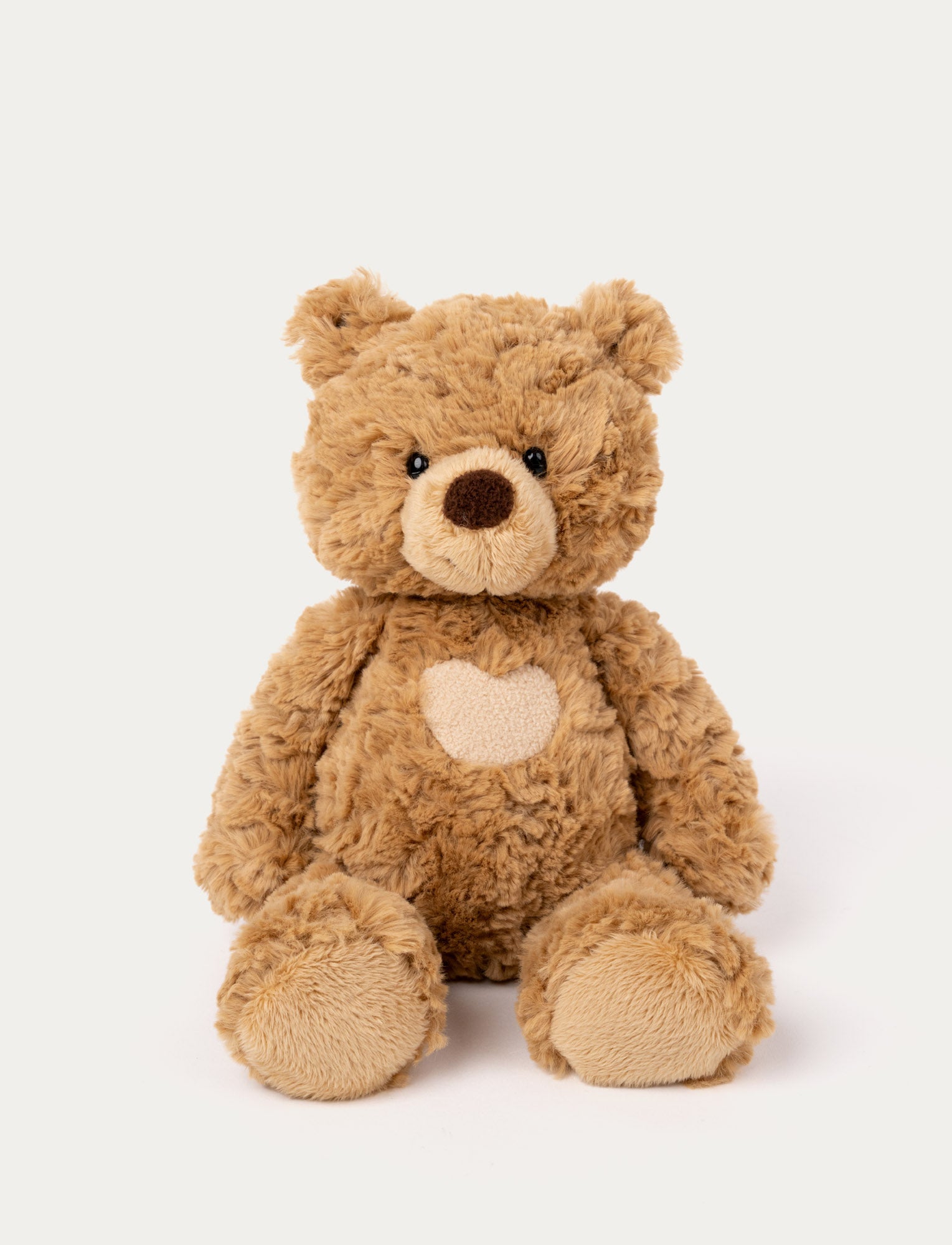  Image of Soft brown teddy bear with a heart on its chest & black shiny eyes. 