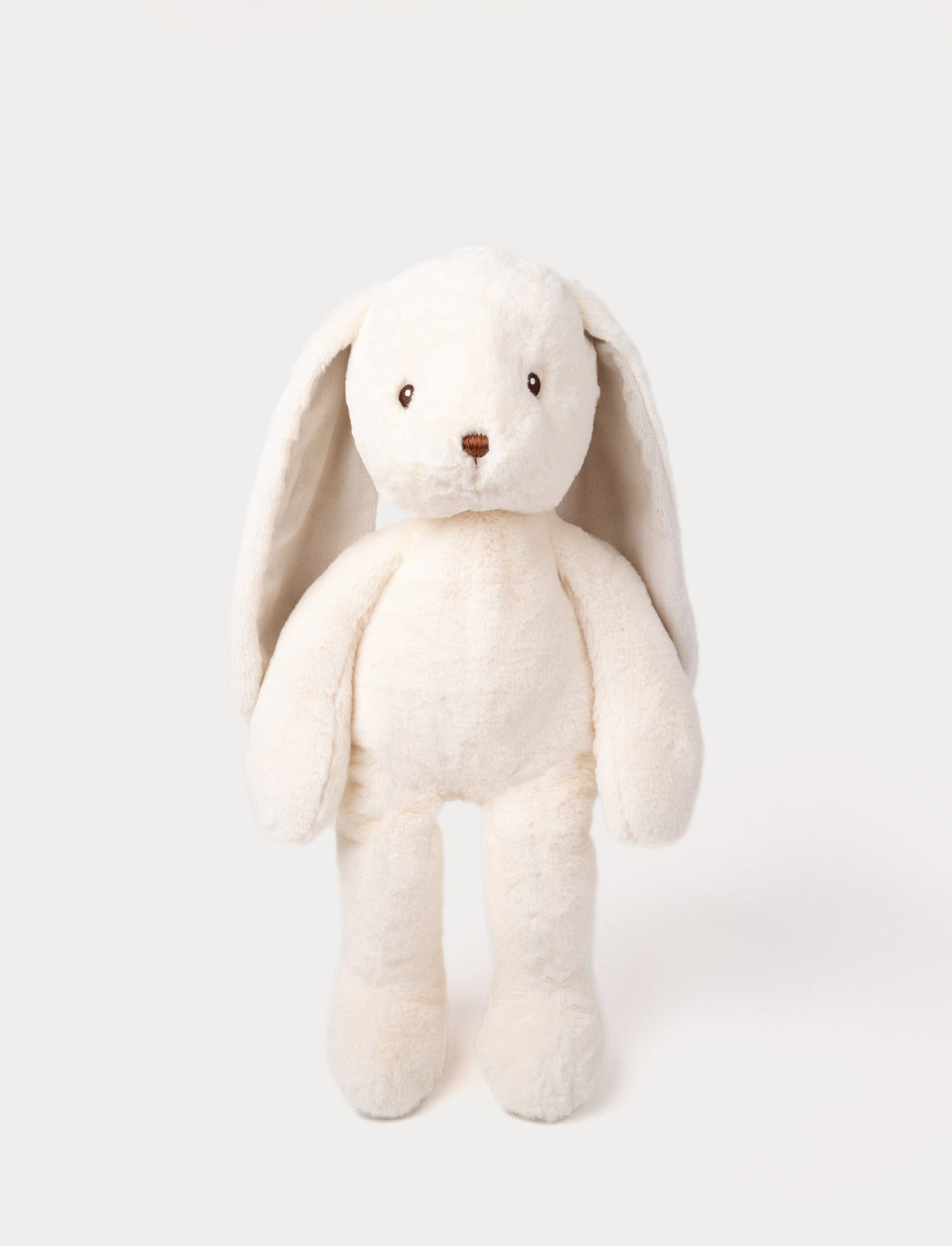 Large, cream-colored plush bunny with soft fur, long floppy ears, embroidered brown eyes, and a brown nose.