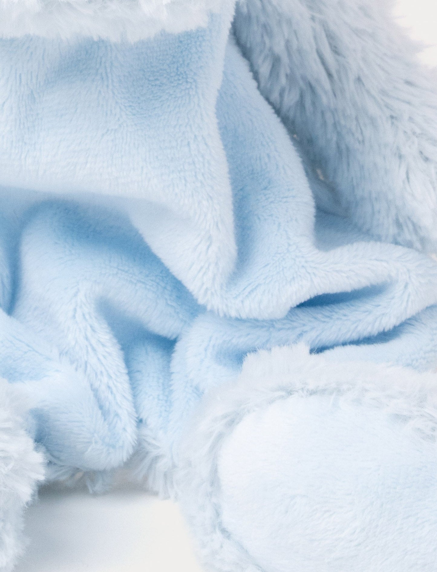 Soft baby blanket with a plush light blue dino head, drak blue spikes, and a cozy fabric body.