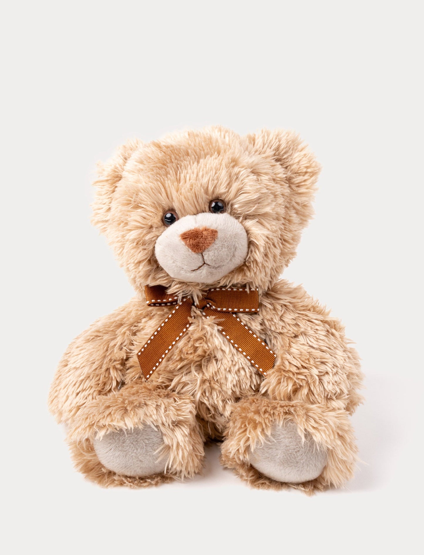 A brown teddy bear with soft, shaggy fur, big eyes, and an elegant bow around his neck.