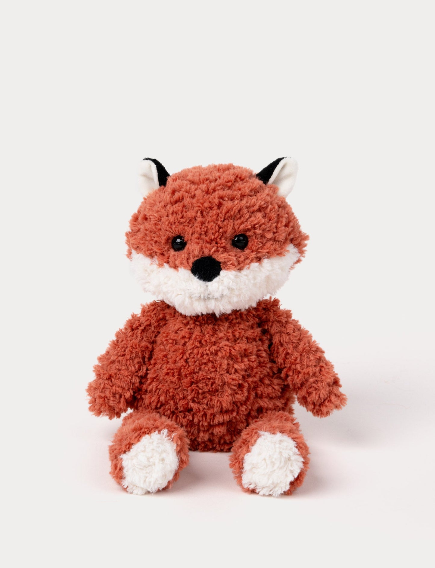 Soft plush fox with a curly-textured red coat, white accents on the face, paws, and ears