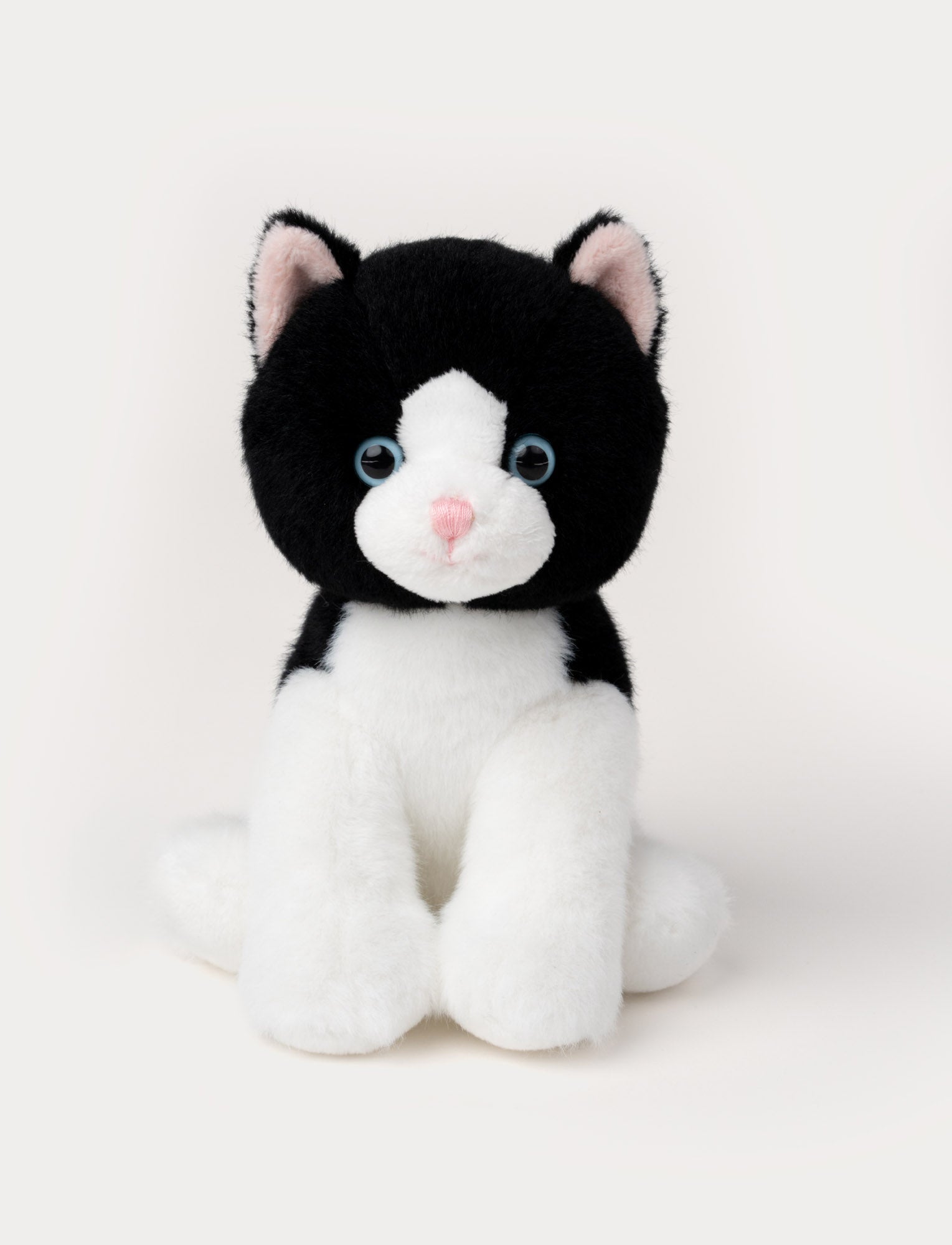  Image of Soft plush cat with black fur, white face and paws, blue eyes, and a pink nose.