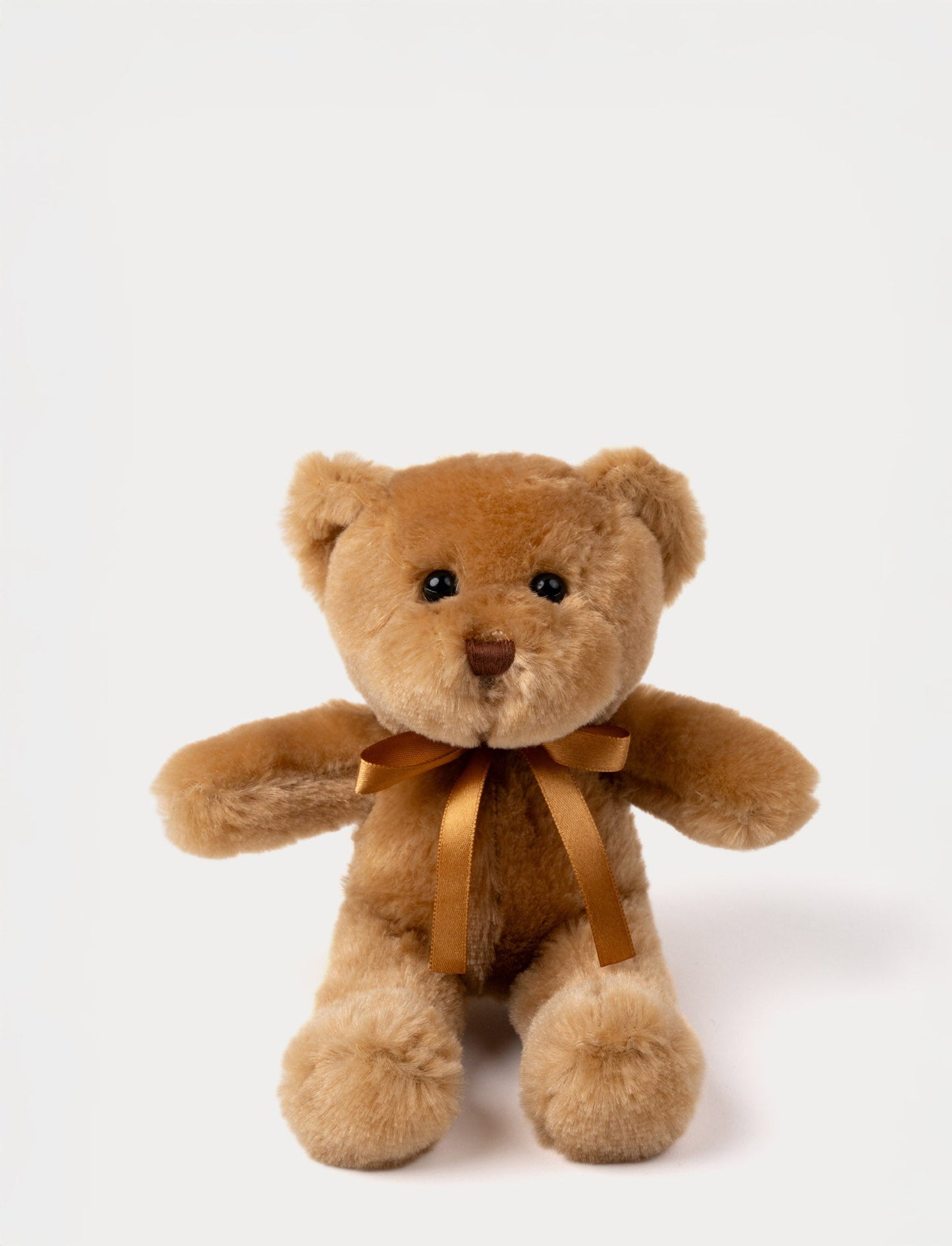 A teddy bear with warm brown fur, an embroidered nose, and an adorable satin bow.