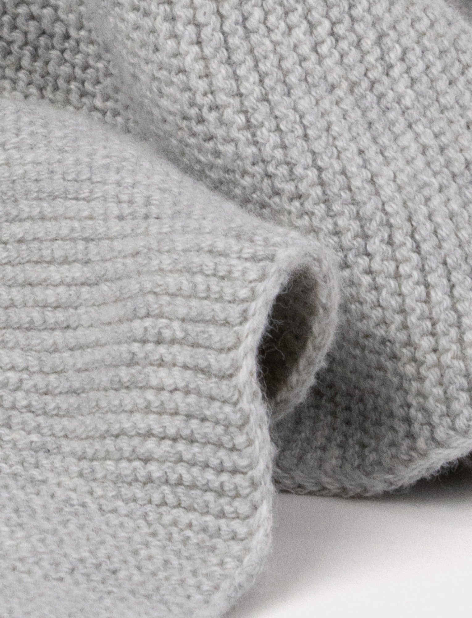  Image of A knitted grey bunny comforter with floppy ears, a stitched face, and a soft textured fabric.