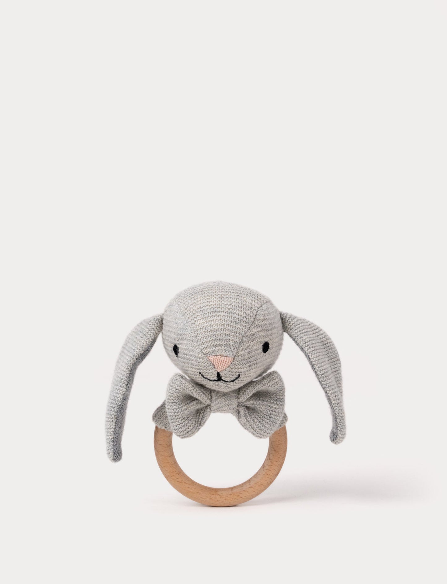 Knitted grey bunny teething ring with floppy ears, embroidered facial features, a bow, and a smooth wooden handle.