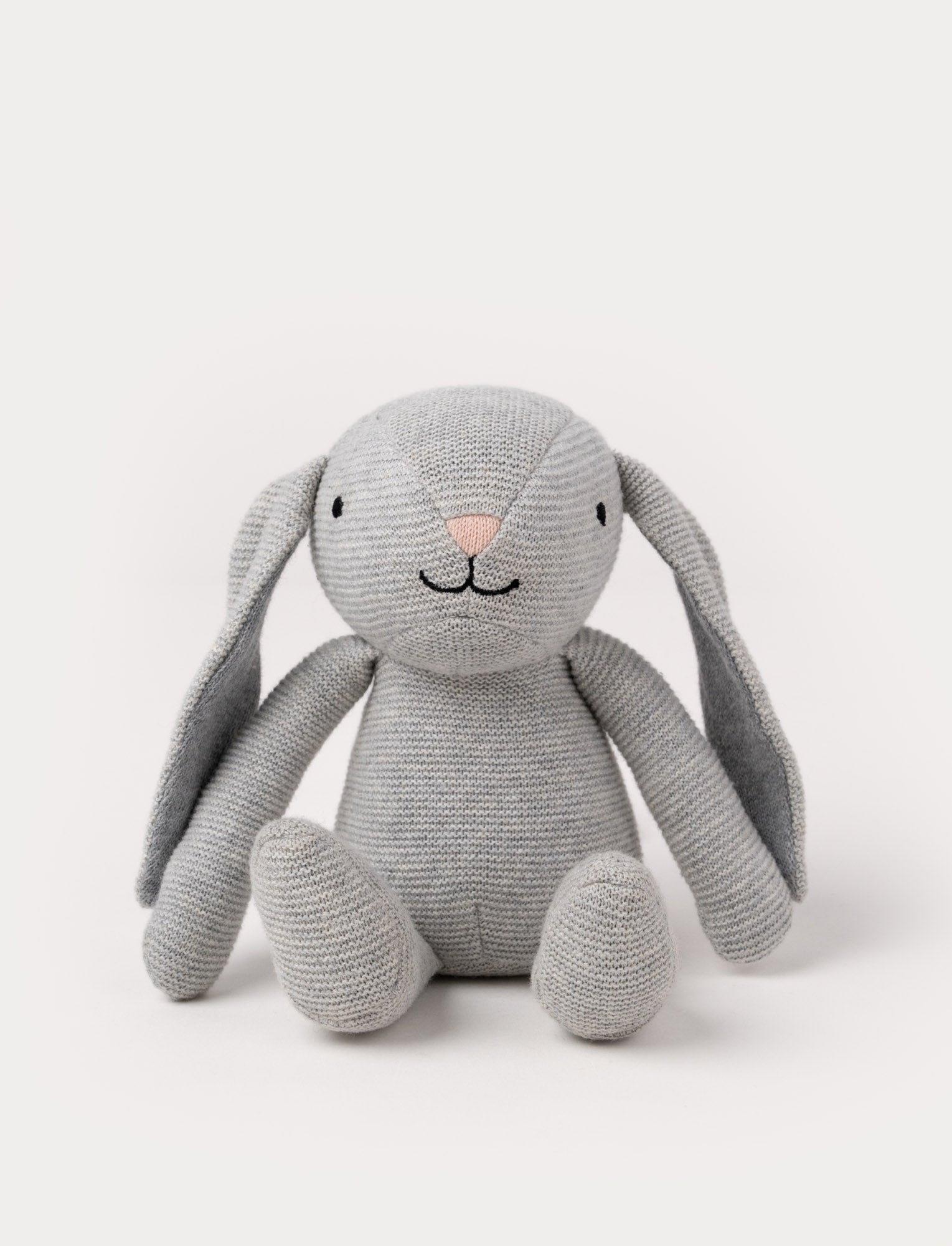  Image of A knitted grey plush bunny with floppy ears, a stitched face, and a soft textured body.