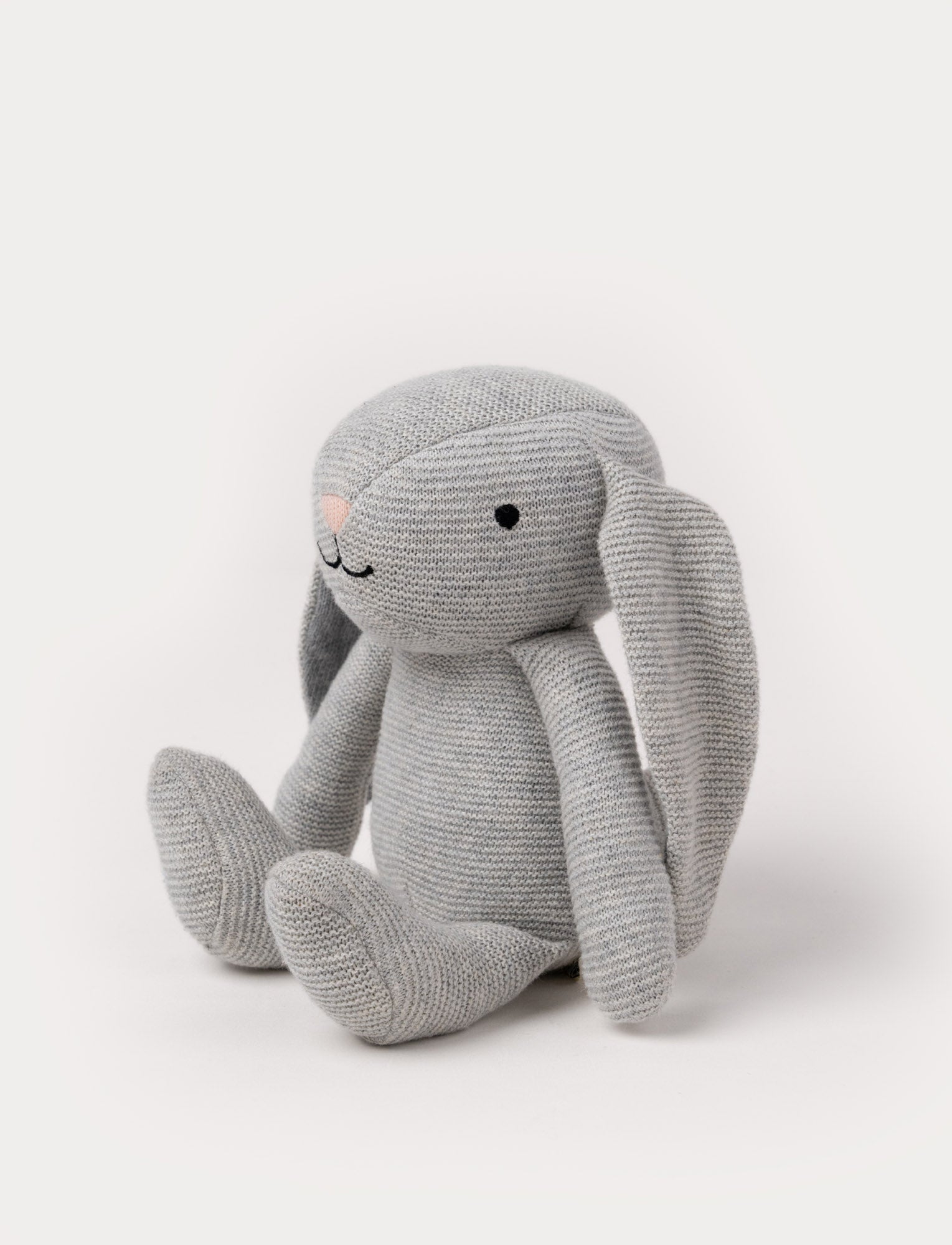  Image of A knitted grey plush bunny with floppy ears, a stitched face, and a soft textured body.