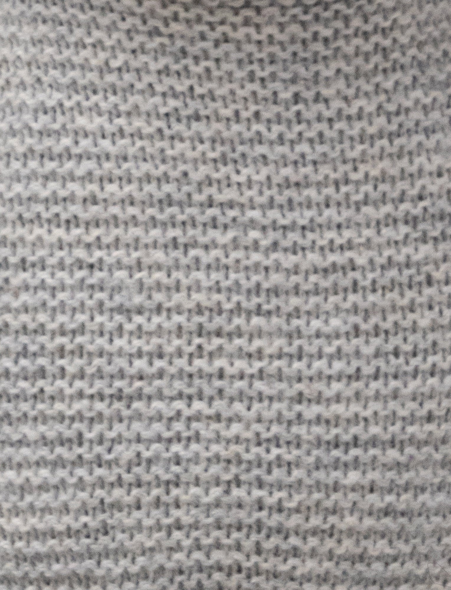  Image of A knitted grey plush bunny with floppy ears, a stitched face, and a soft textured body.