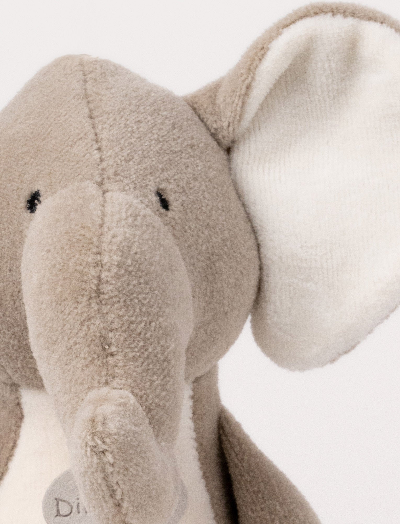  Image of A soft plush beige bunny  with broaded eyes and nose, white, and brown details.