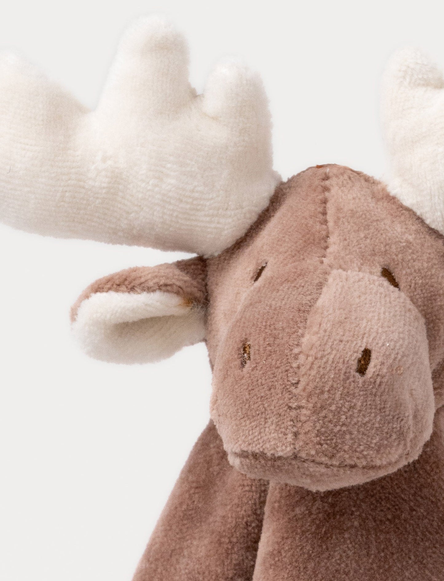 A soft brown moose baby blanket with white antlers, a stitched face and white and brown details.