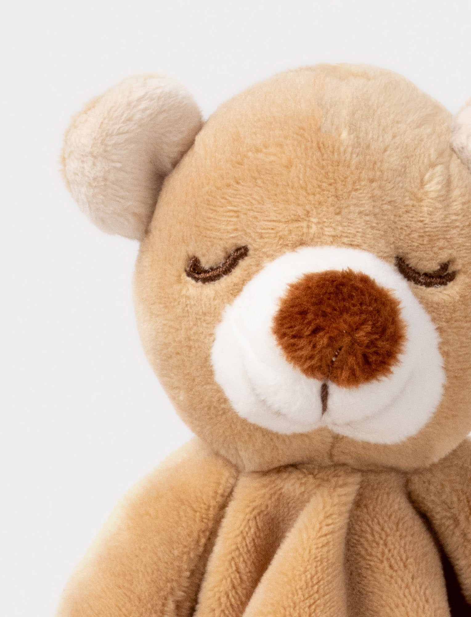  Image of Soft baby blanket with a plush brown bear head, closed eyes, and cream-trimmed edges.