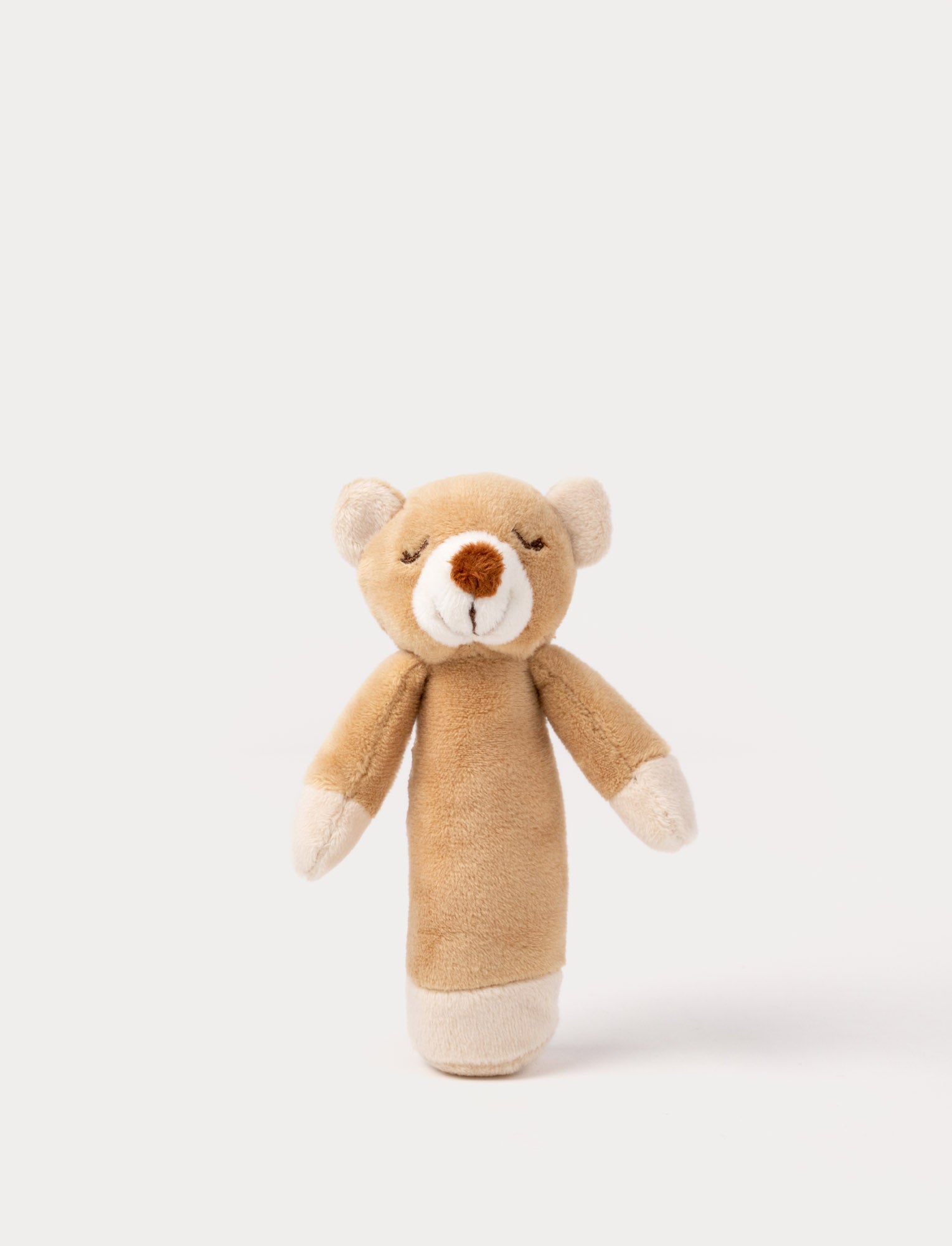  Image of Soft plush bear rattle with a light brown body, embroidered sleeping eyes, a white muzzle, and white accents on the hands and base.