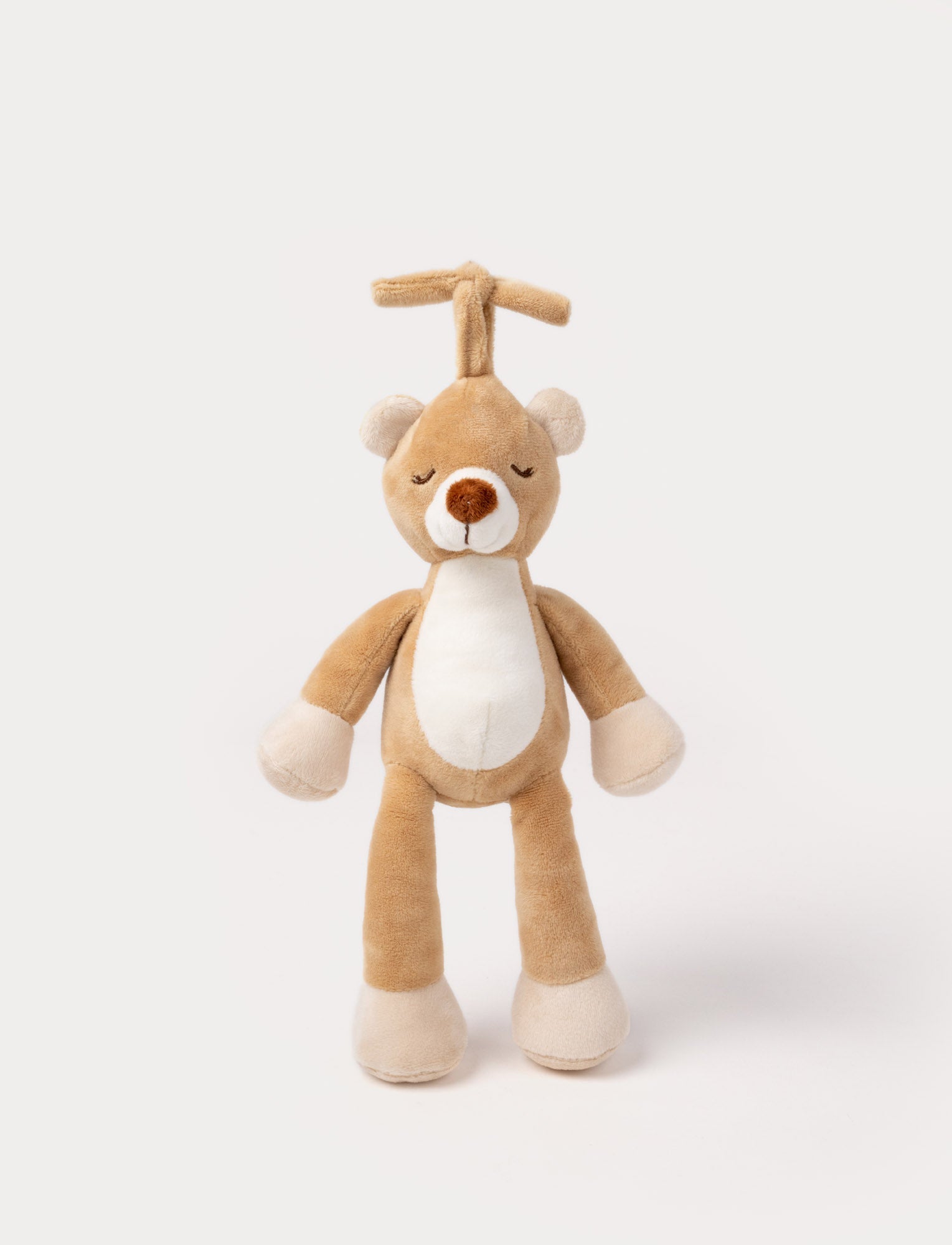 Image of A plush brown teddy bear music box with a white belly, closed eyes, and a hanging loop.