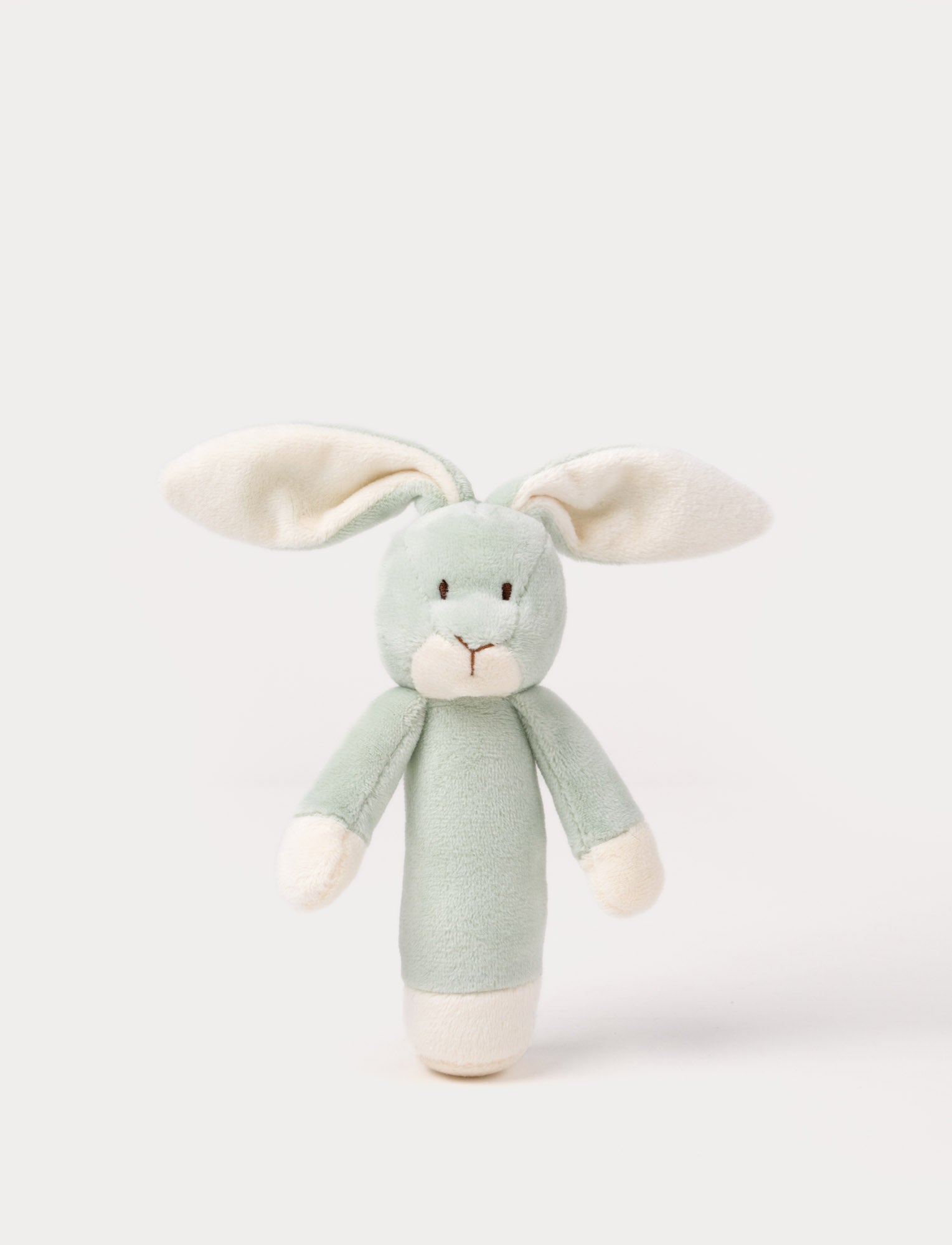  Image of Soft plush bunny rattle with a light green body, long floppy ears, embroidered eyes, and white accents on the hands and base.