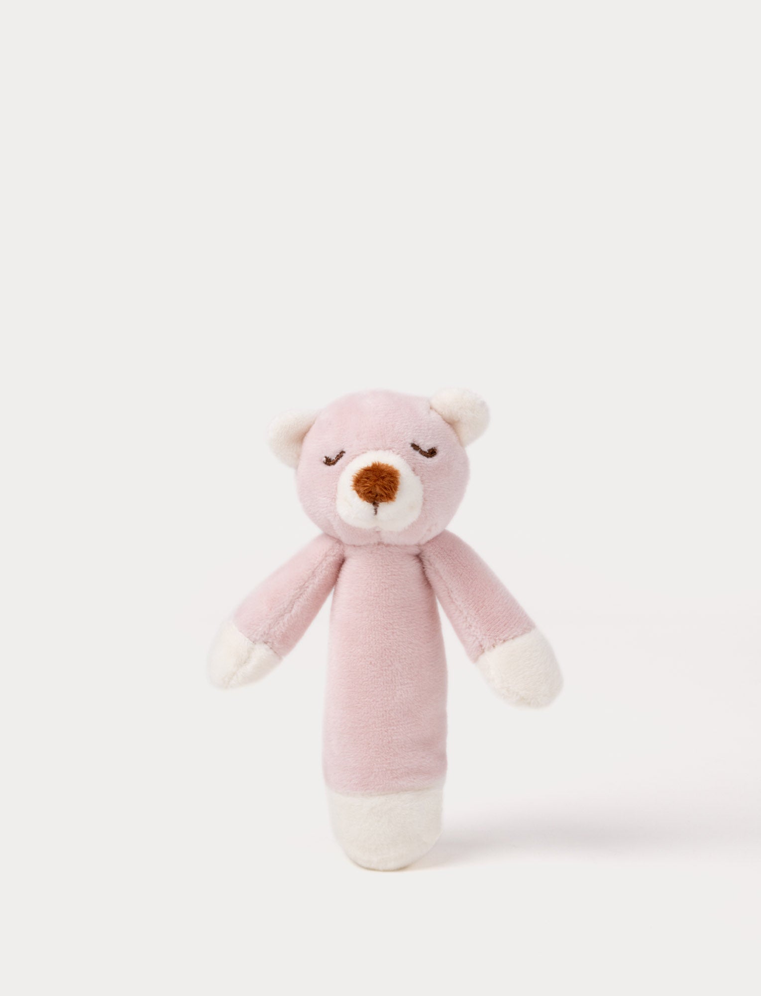  Image of Soft plush bear rattle with a dusty pink body, embroidered sleeping eyes, a white muzzle, and white accents on the hands and base.