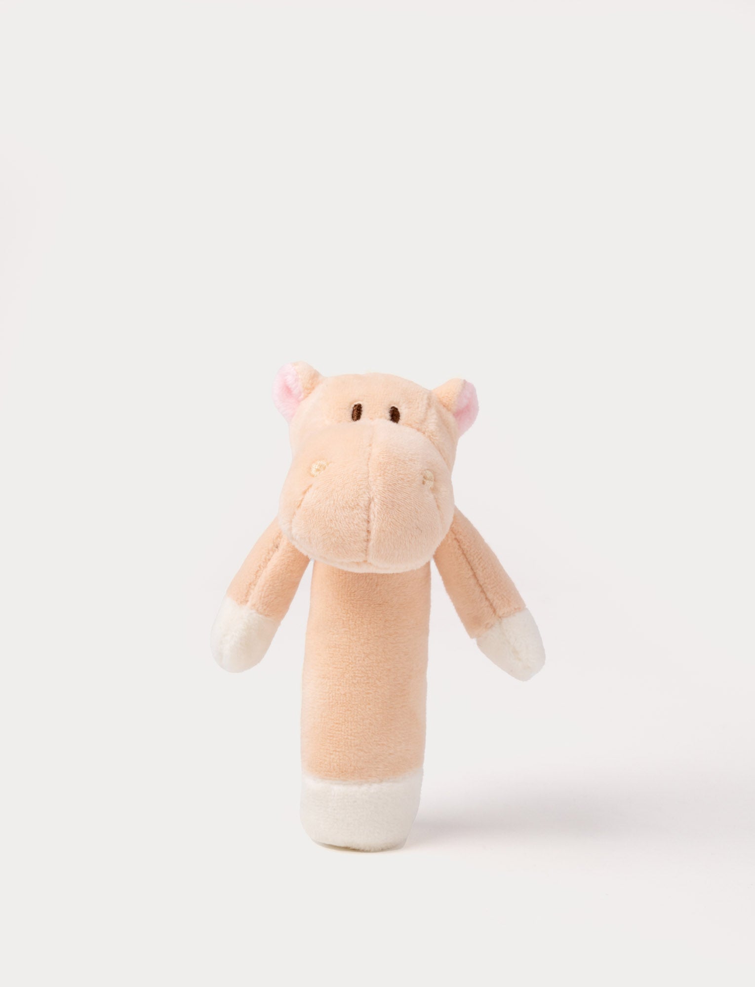  Image of Soft plush hippo rattle with apricot body, embroidered eyes, small pink ears, and white accents on the hands and base.
