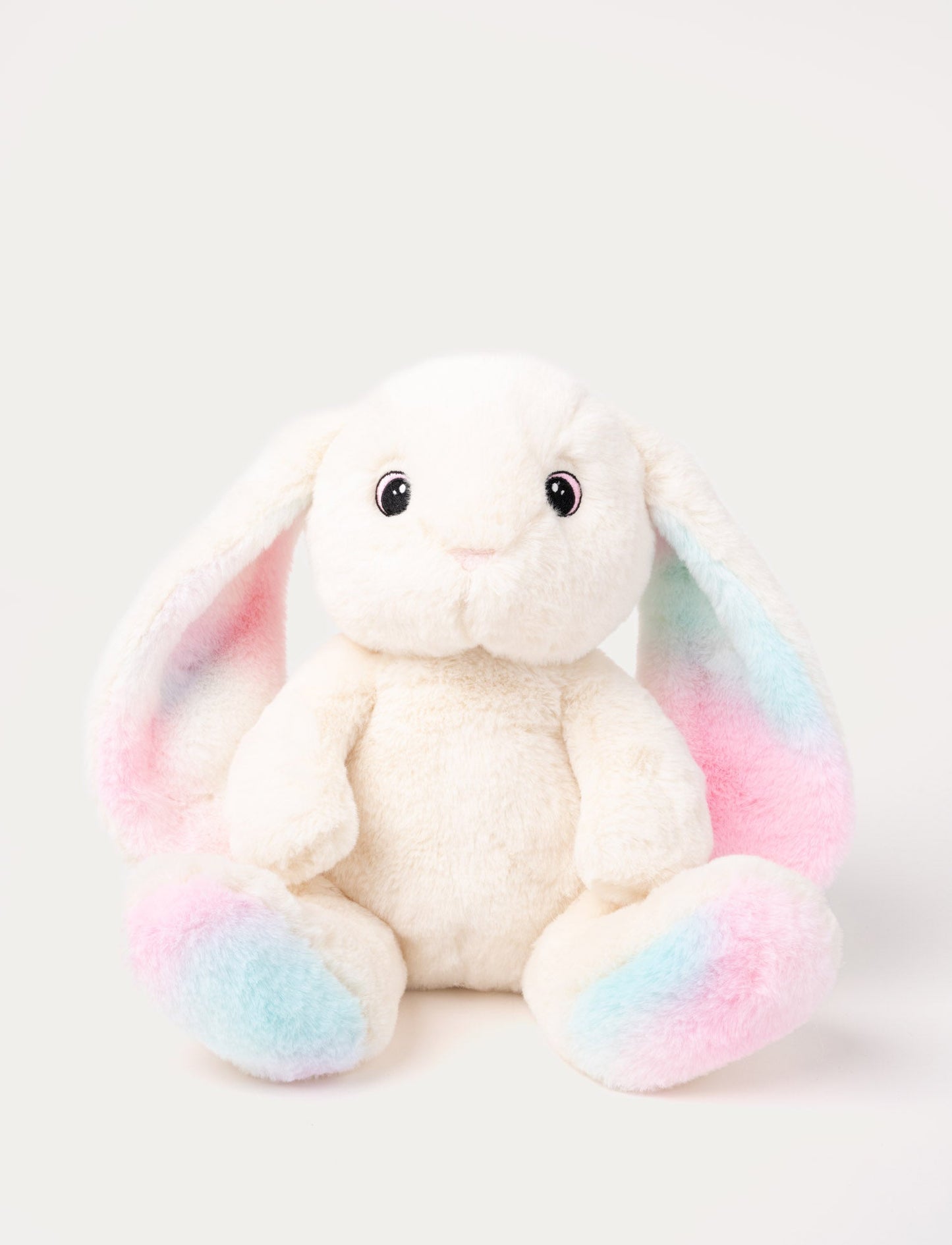 A bunny with cream-colored fur, colorful pastel details on her ears and paws, embroidered eyes.