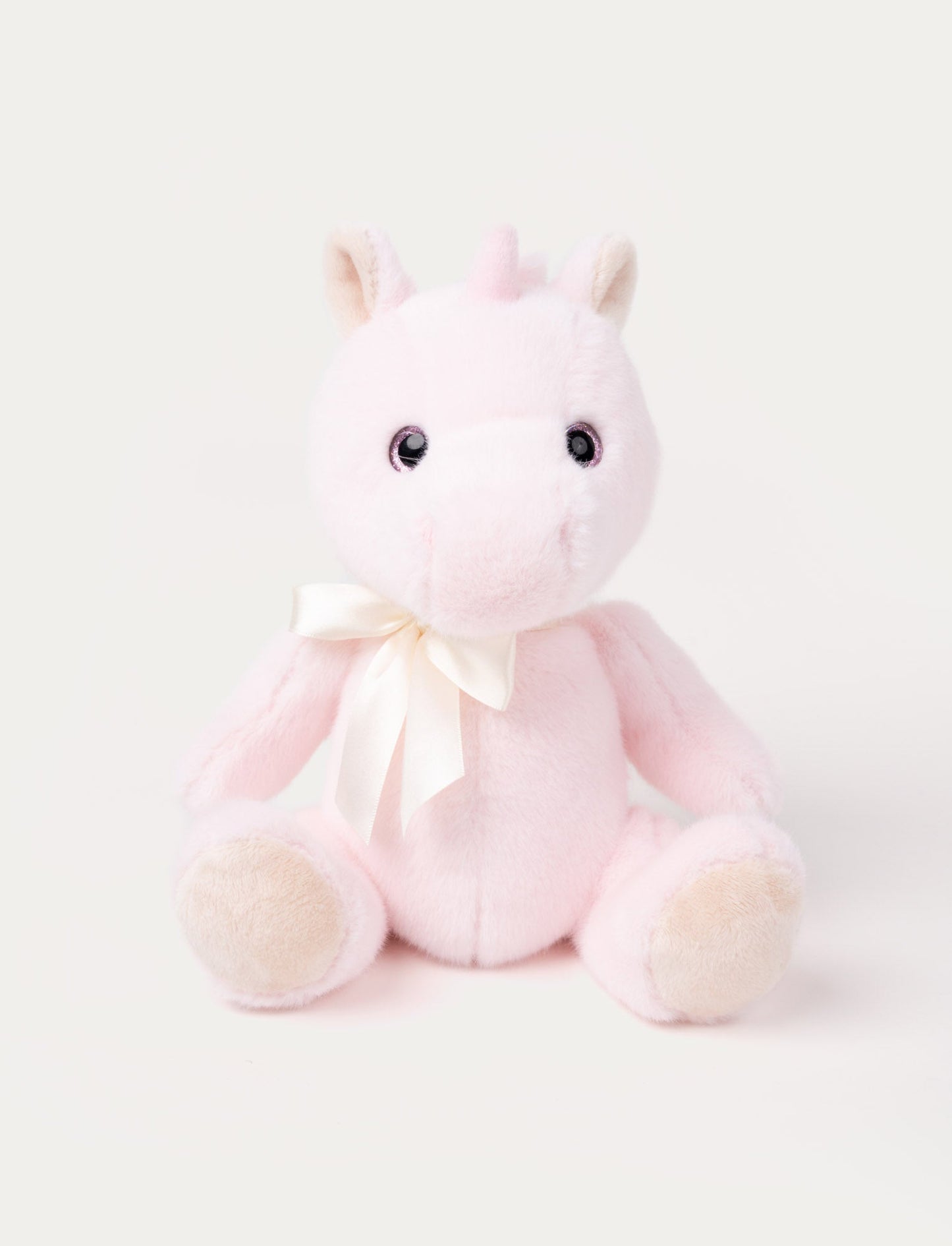 A pink unicorn with a satin bow, sparkling eyes, fluffy ears, and silky, cashmere-like fur.
