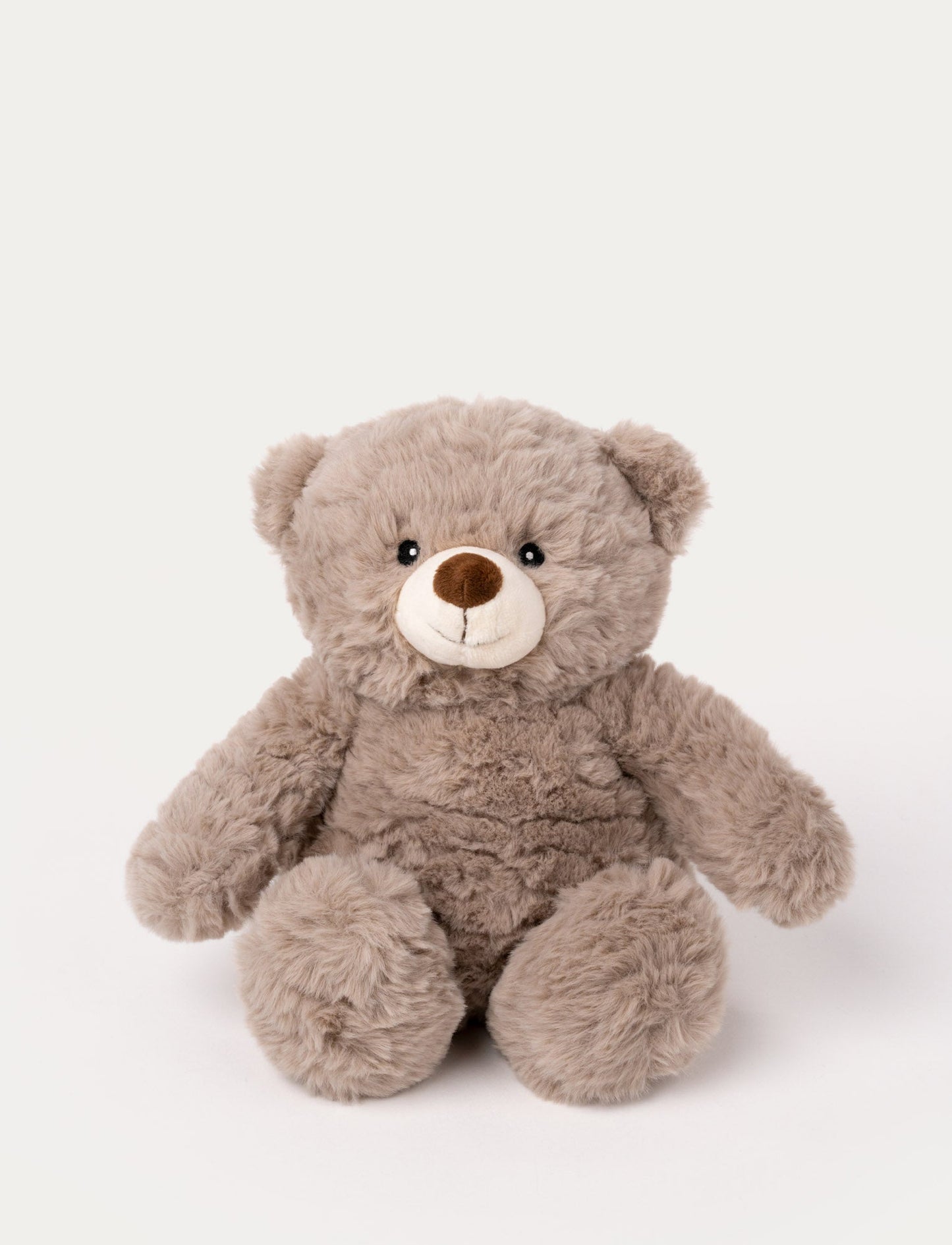 Soft beige teddy bear plush with a round body, fluffy fur, and a stitched smiling face.