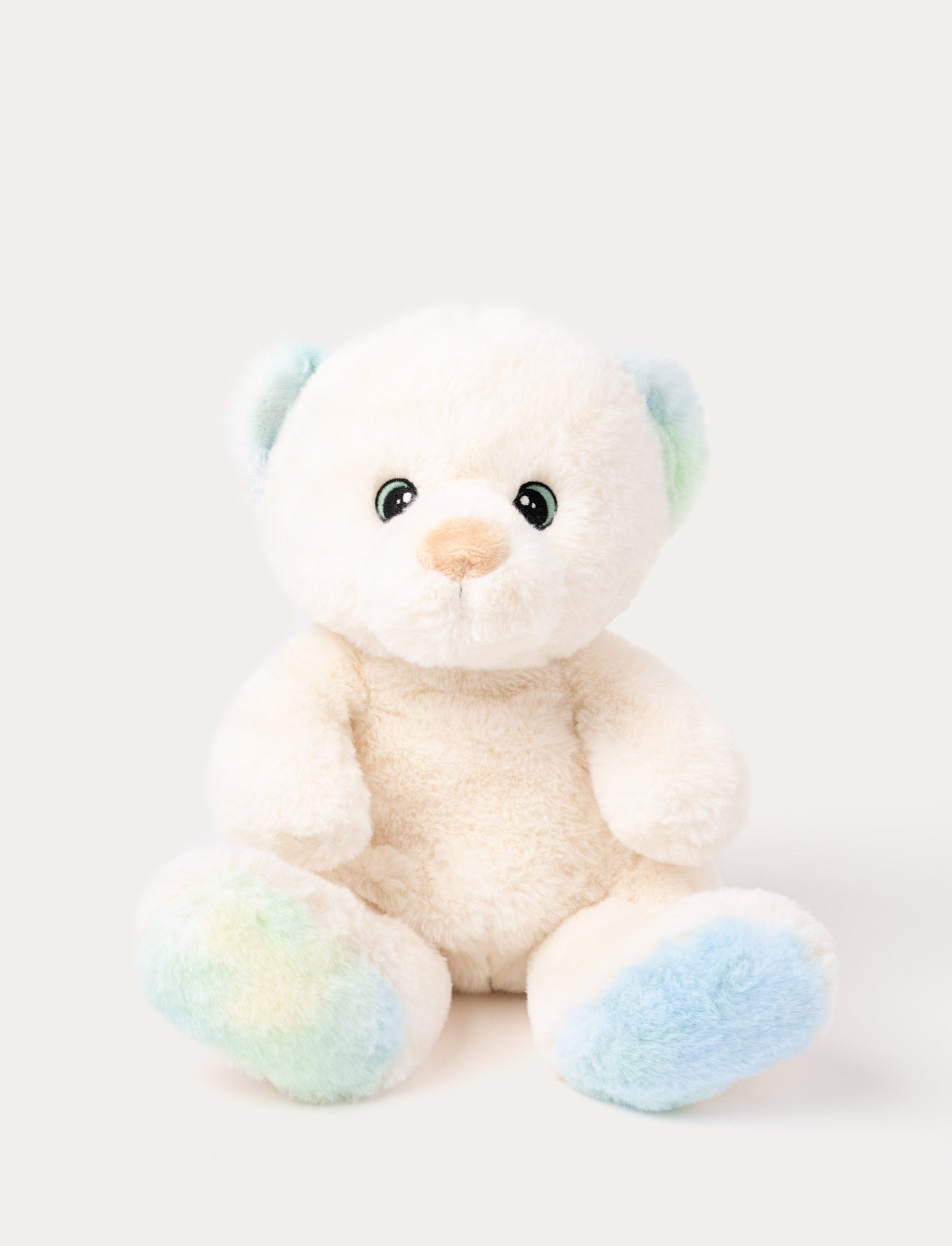  Image of A teddy bear with cream-colored fur and pastel details on his ears and feet, with embroidered eyes.