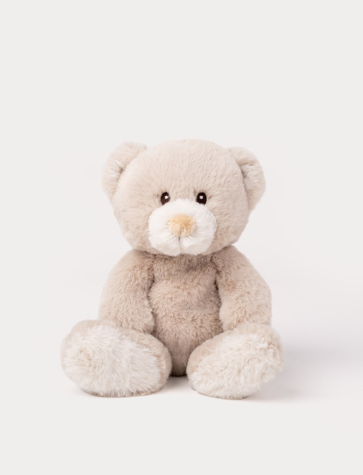 A beige teddy bear with luxurious soft material, faux suede detail on its back, and embroidered eyes.