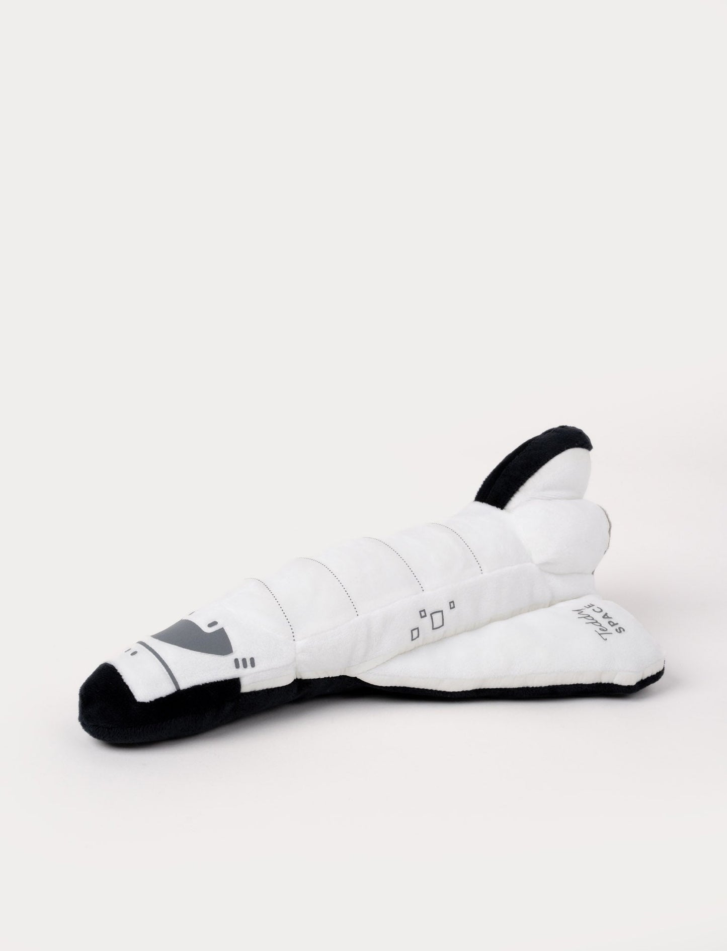 Soft white space shuttle plush with black accents, embroidered details, and "Teddy SPACE" stitched on the wing.