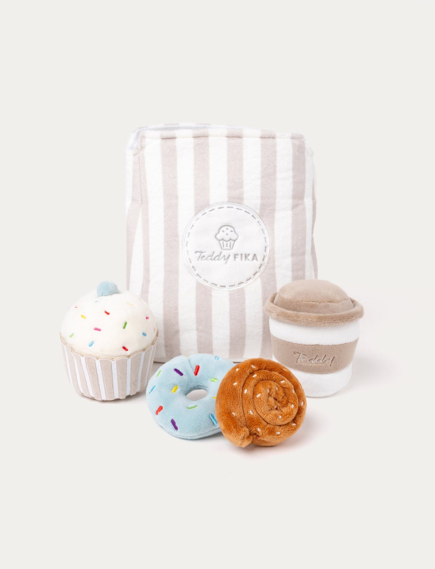 Soft plush fika set including a cupcake, donut, cinnamon roll, coffee cup, and a striped "Teddy FIKA" bag.