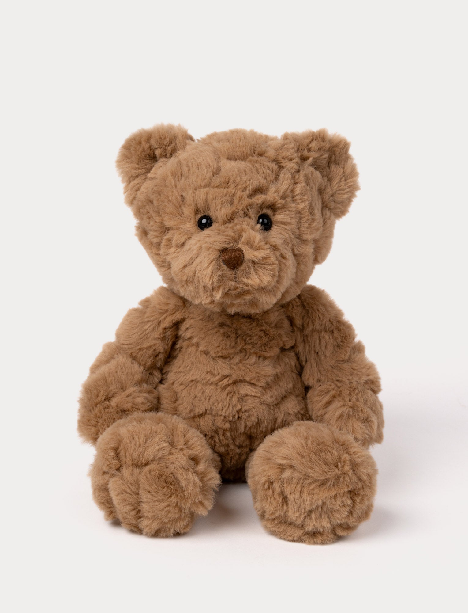  Image of Soft brown teddy bear plush with fluffy fur, a stitched nose, and shiny black eyes.