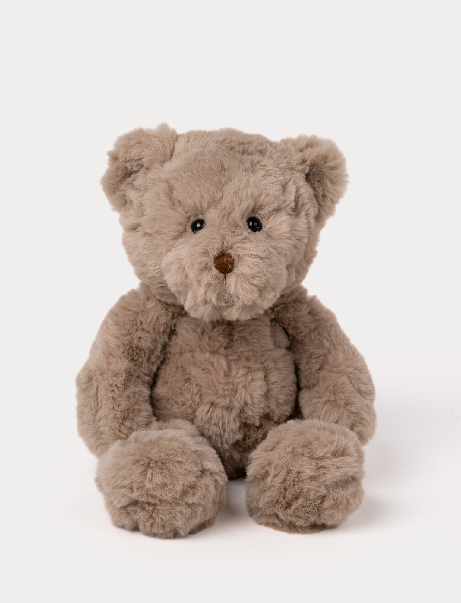  Image of Soft brown teddy bear plush with fluffy fur, a stitched brown nose, and shiny black eyes.